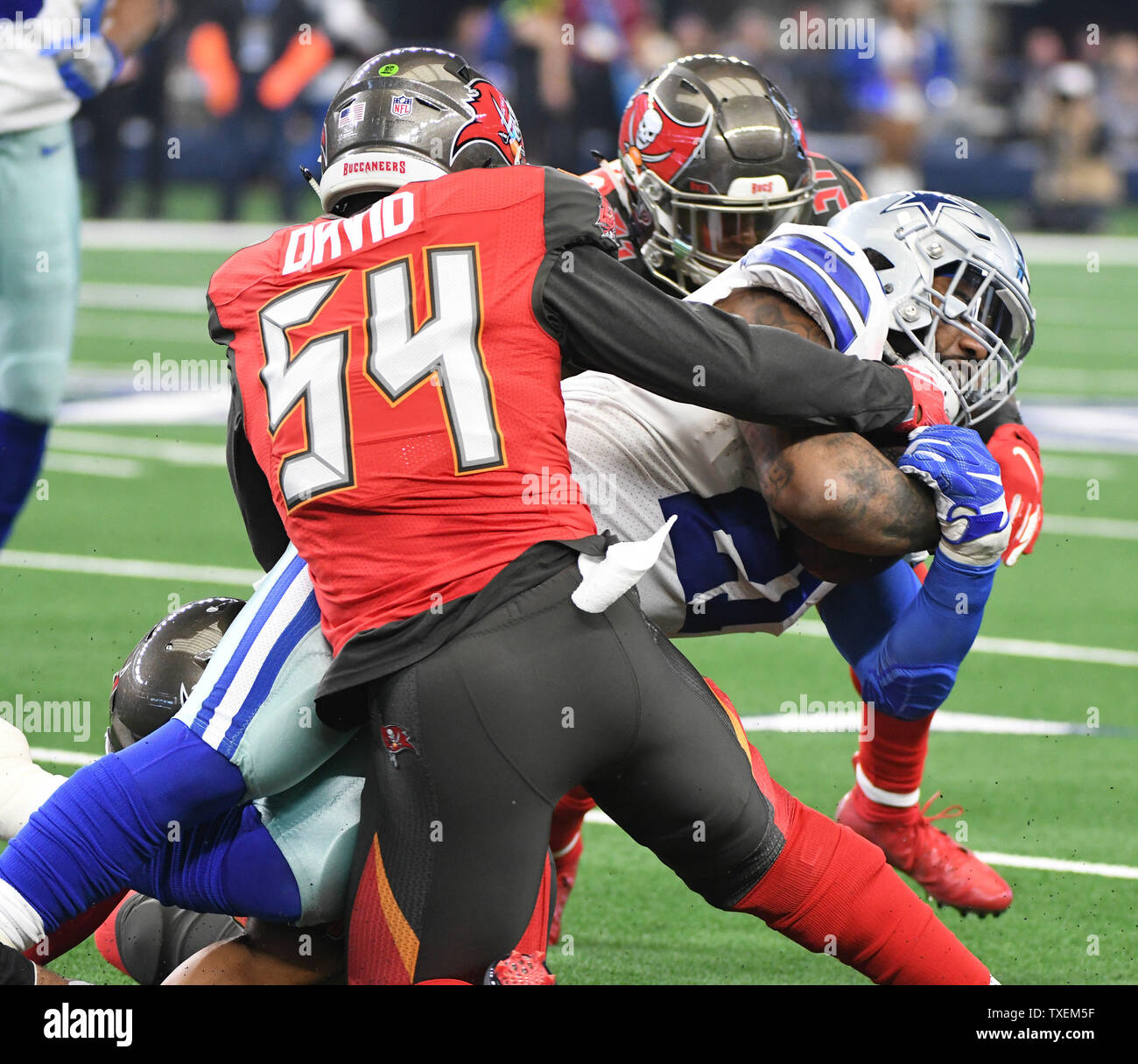 Tampa Bay Buccaneers Lavonte David (54) e Andrew Adams smettere di Dallas Cownboys Ezechiele Elliott dopo un 1-cantiere guadagno durante il loro gioco di NFL AT&T Stadium di Arlington, Texas, il 23 dicembre 2018. Foto di Ian Halperin/UPI Foto Stock