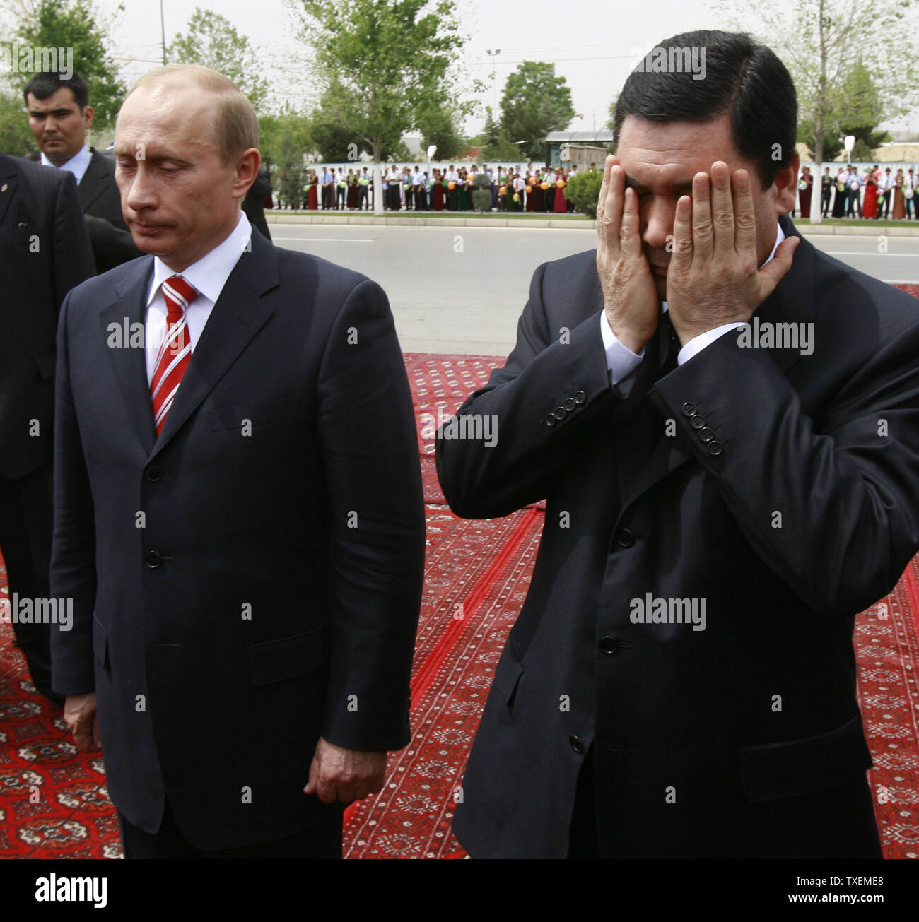 Il presidente russo Vladimir Putin (L) si erge come il suo omologo turkmeno Gurbanguli Berdymukhamedov prega prima della posa della prima pietra di una nuova scuola russa di Aşgabat, Turkmenistan il 11 maggio 2007. La visita di Putin in in Asia centrale giunge in un momento in cui l'aumento della concorrenza per il Turkmenistan è vaste riserve di gas dopo la morte dello scorso anno del Presidente Saparmurat Niyazov chi ha firmato accordi per la costruzione di gasdotti di esportazione in Cina. (UPI foto/Anatoli Zhdanov) Foto Stock