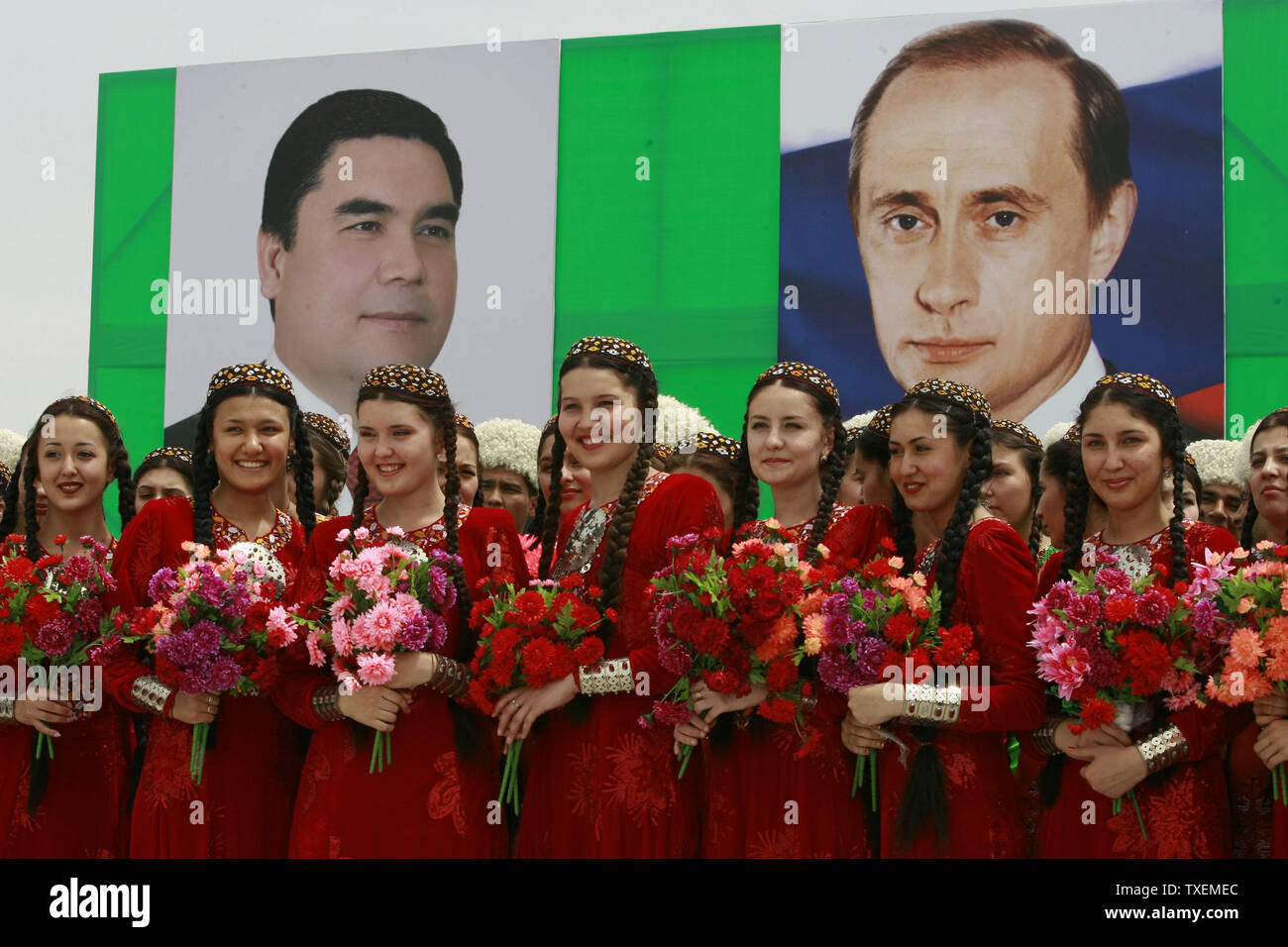 Ragazze turkmene stand sotto i ritratti di turkmeni e presidenti russo in attesa di salutare il Presidente Vladimir Putin a Aşgabat, Turkmenistan il 11 maggio 2007. La visita di Putin in in Asia centrale giunge in un momento in cui l'aumento della concorrenza per il Turkmenistan è vaste riserve di gas dopo la morte dello scorso anno del Presidente Saparmurat Niyazov chi ha firmato accordi per la costruzione di gasdotti di esportazione in Cina. (UPI foto/Anatoli Zhdanov) Foto Stock