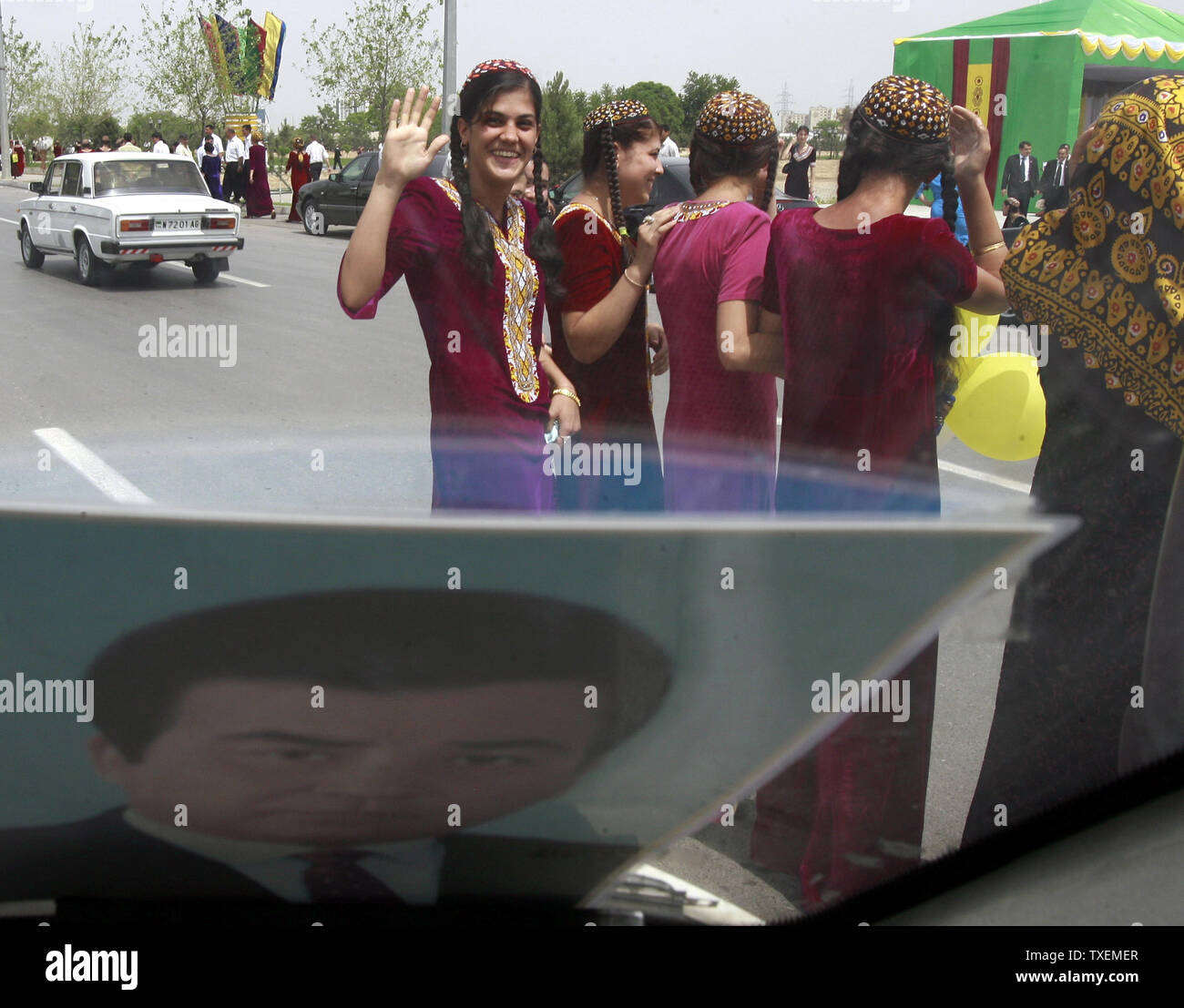 Una ragazza turkmena onde per una vettura con una foto del paese del nuovo Presidente Gurbanguli Berdymukhamedov sul vetro anteriore, Aşgabat, Turkmenistan il 11 maggio 2007. Secondo una legge fatta dall ex Presidente turkmeno Saparmurat Niyazov a tutte le donne del paese deve indossare abiti lunghi. (UPI foto/Anatoli Zhdanov) Foto Stock