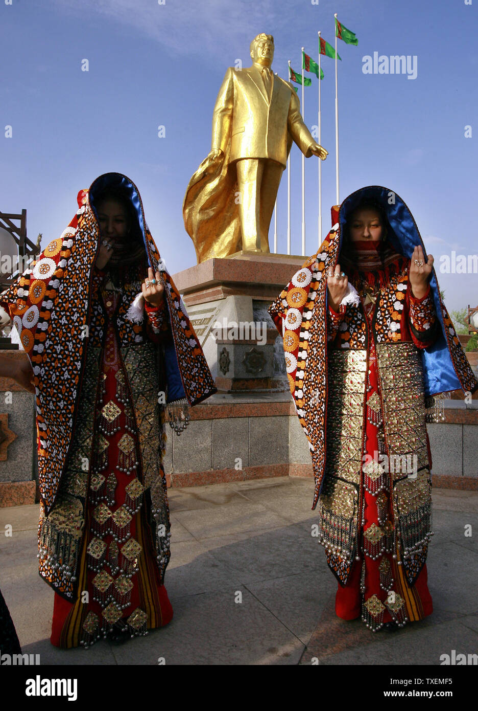 Due spose turkmeno in costumi tradizionali pagare il loro rispetto alla principale placcato oro monumento dell ex Presidente turkmeno Saparmurat Niyazov in Aşgabat, Turkmenistan il 11 maggio 2007. Tutte le coppie appena sposate devono visitare questo monumento. (UPI foto/Anatoli Zhdanov) Foto Stock