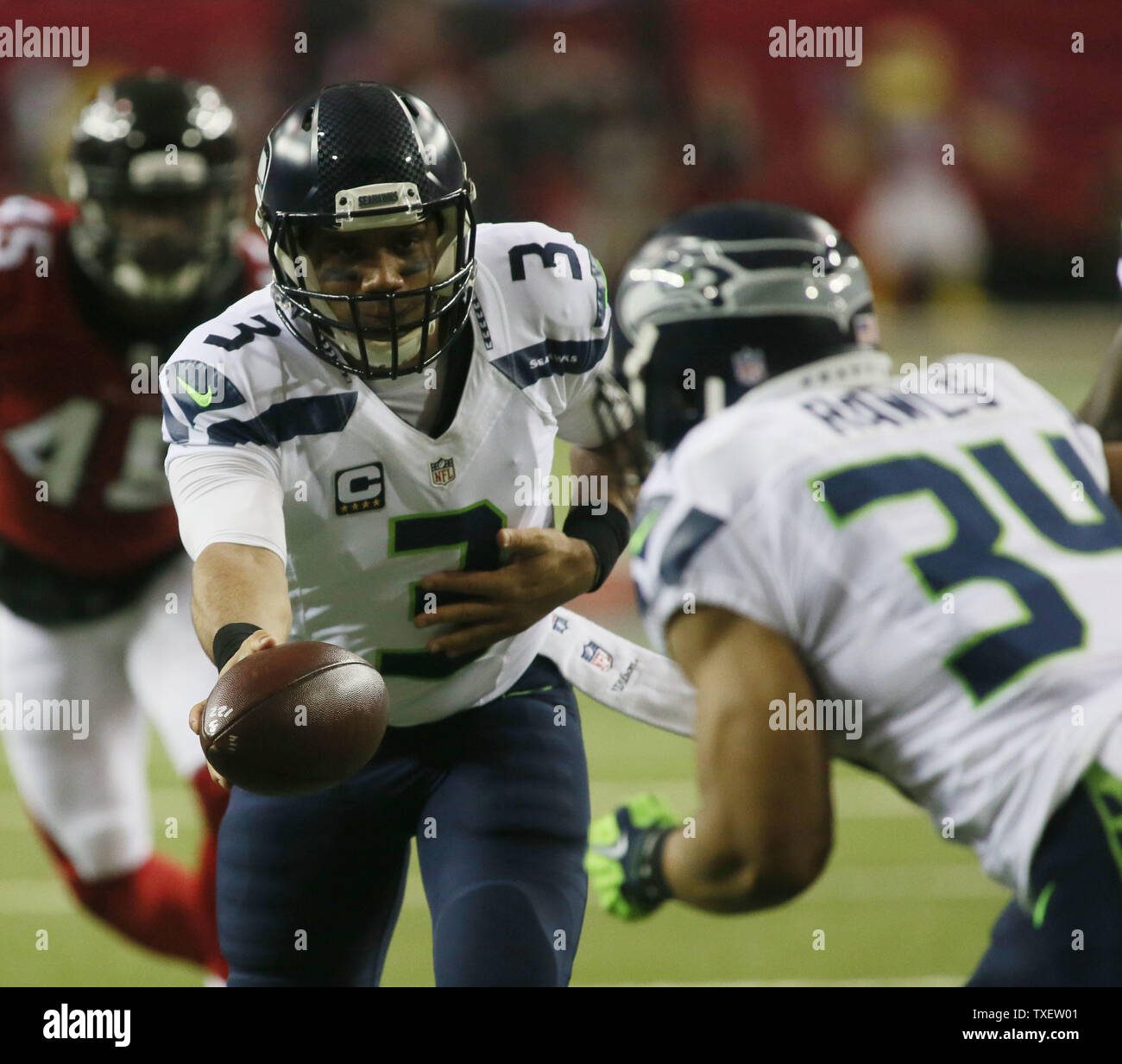 Seattle Seahawks quarterback Russell Wilson Hands off a Thomas Rawls durante il primo trimestre azione contro i falchi di Atlanta nella loro playoff NFC gioco presso il Georgia Dome di Atlanta il 14 gennaio 2017. Foto di Phil Skinner/UPI Foto Stock