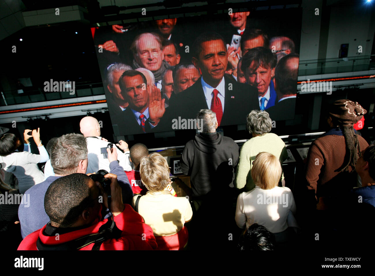 La folla guarda su un grande schermo televisivo interno il Newseum a Washington il 20 gennaio 2009 come Barack Obama è giurato in quanto la quarantaquattresima Presidente degli Stati Uniti. (UPI foto/Arianne Teeple) Foto Stock