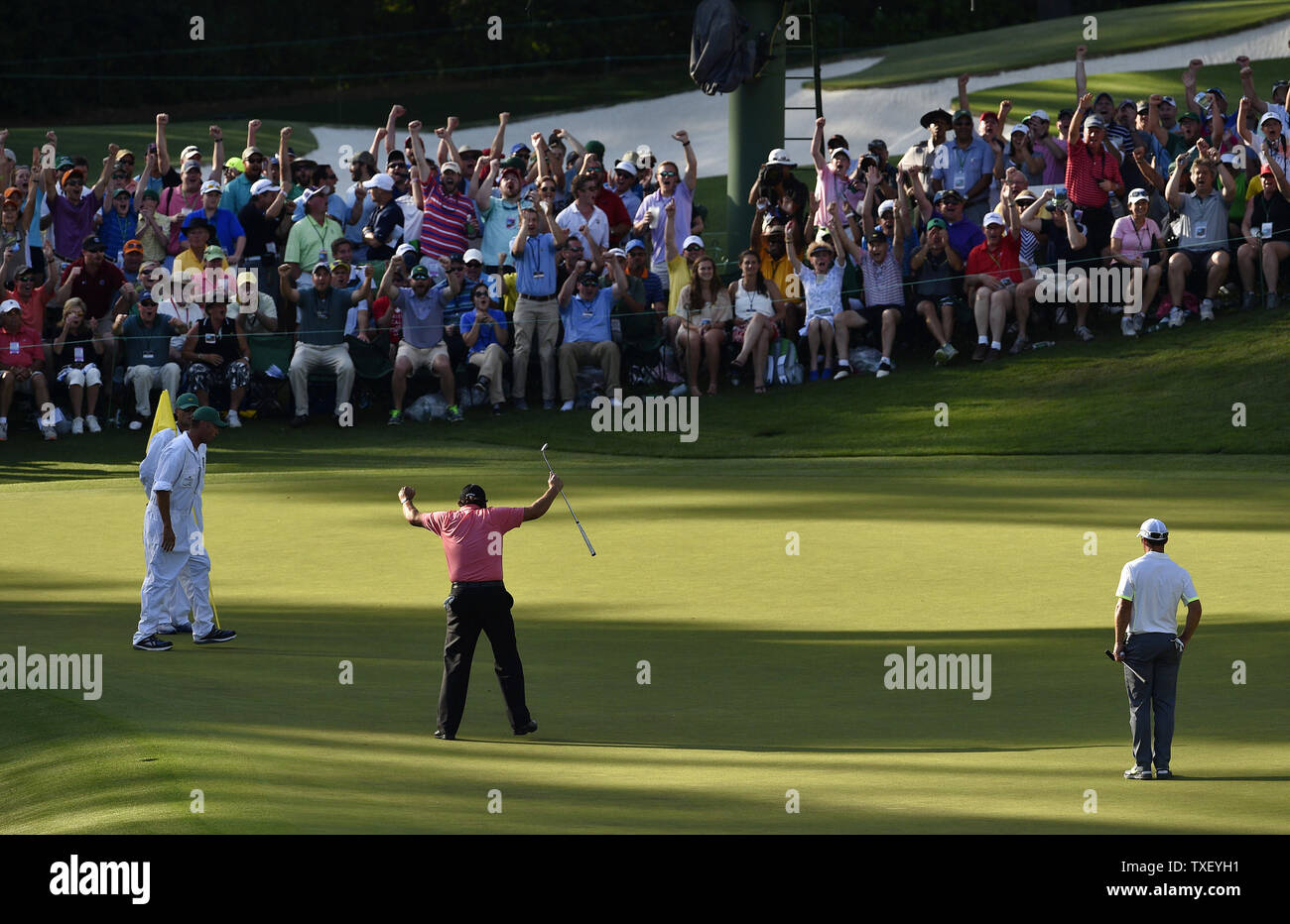 Patroni celebrare con Phil Mickelson dopo che egli compie un lungo putt per il birdie il sedicesimo foro nel terzo round del 2015 Masters a Augusta National Golf Club a Augusta, in Georgia il 11 aprile 2015. Foto di Kevin Dietsch/UPI Foto Stock