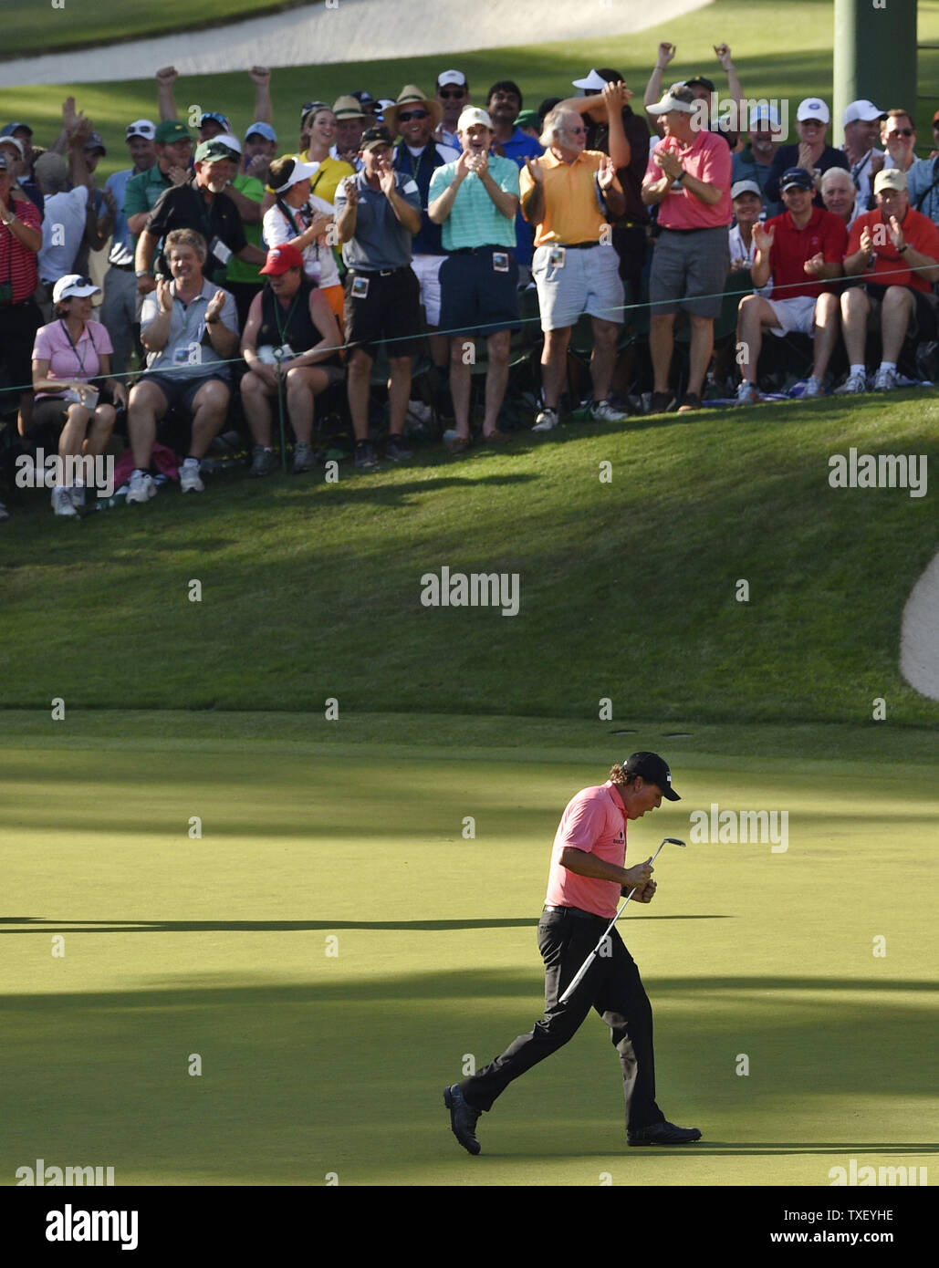 Patroni celebrare con Phil Mickelson dopo che egli compie un lungo putt per il birdie il sedicesimo foro nel terzo round del 2015 Masters a Augusta National Golf Club a Augusta, in Georgia il 11 aprile 2015. Foto di Kevin Dietsch/UPI Foto Stock