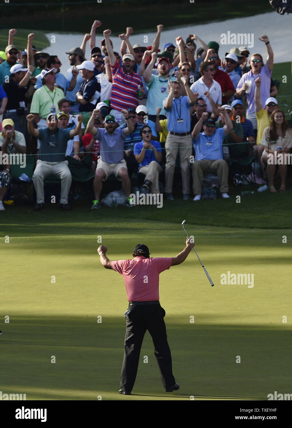 Patroni celebrare con Phil Mickelson dopo che egli compie un lungo putt per il birdie il sedicesimo foro nel terzo round del 2015 Masters a Augusta National Golf Club a Augusta, in Georgia il 11 aprile 2015. Foto di Kevin Dietsch/UPI Foto Stock