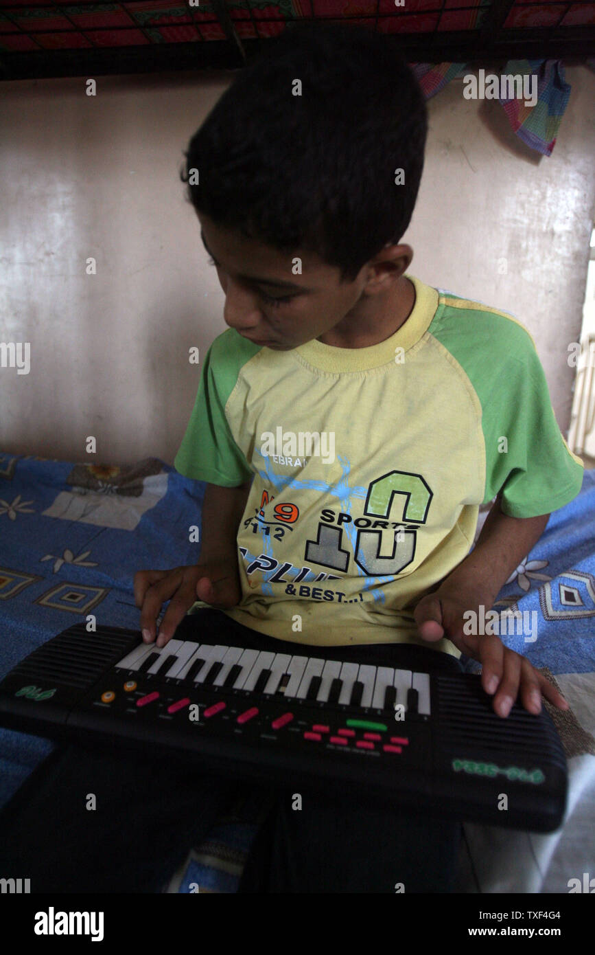 Jassim Abbas riproduce la musica a casa in Iraq, un orfanotrofio creato due anni fa per combattere il gonfiore numero di senzatetto i bambini di Baghdad musulmana baraccopoli sciita di Sadr City il Martedì 19 Giugno, 2007. L'Iraq House ha 25 orfani di età compresa da 5 a 14 ed è composta da cinque uomini adulti. La maggior parte degli orfani sono qui perché uno o entrambi i genitori sono stati uccisi nella violenza settaria. Altri sono qui perché sono stati abbandonati. La comunità locale supporta l orfanotrofio da donazioni. (UPI foto/Adel Abd Al-Hassan) Foto Stock