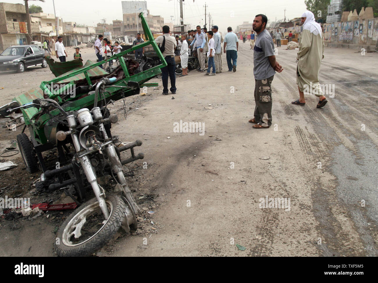 Le persone si radunano intorno a un veicolo distrutto in un auto bomba a Baghdad dell enclave sciita di Sadr City, Iraq, giovedì 30 aprile, 2009. Twin auto bombe devastato una famosa area dello shopping di Baghdad il più grande quartiere sciita Mercoledì, uccidendo almeno 41 persone in un altro attacco potente da sospetti ribelli sunniti. (UPI foto/Ali Jasim) Foto Stock