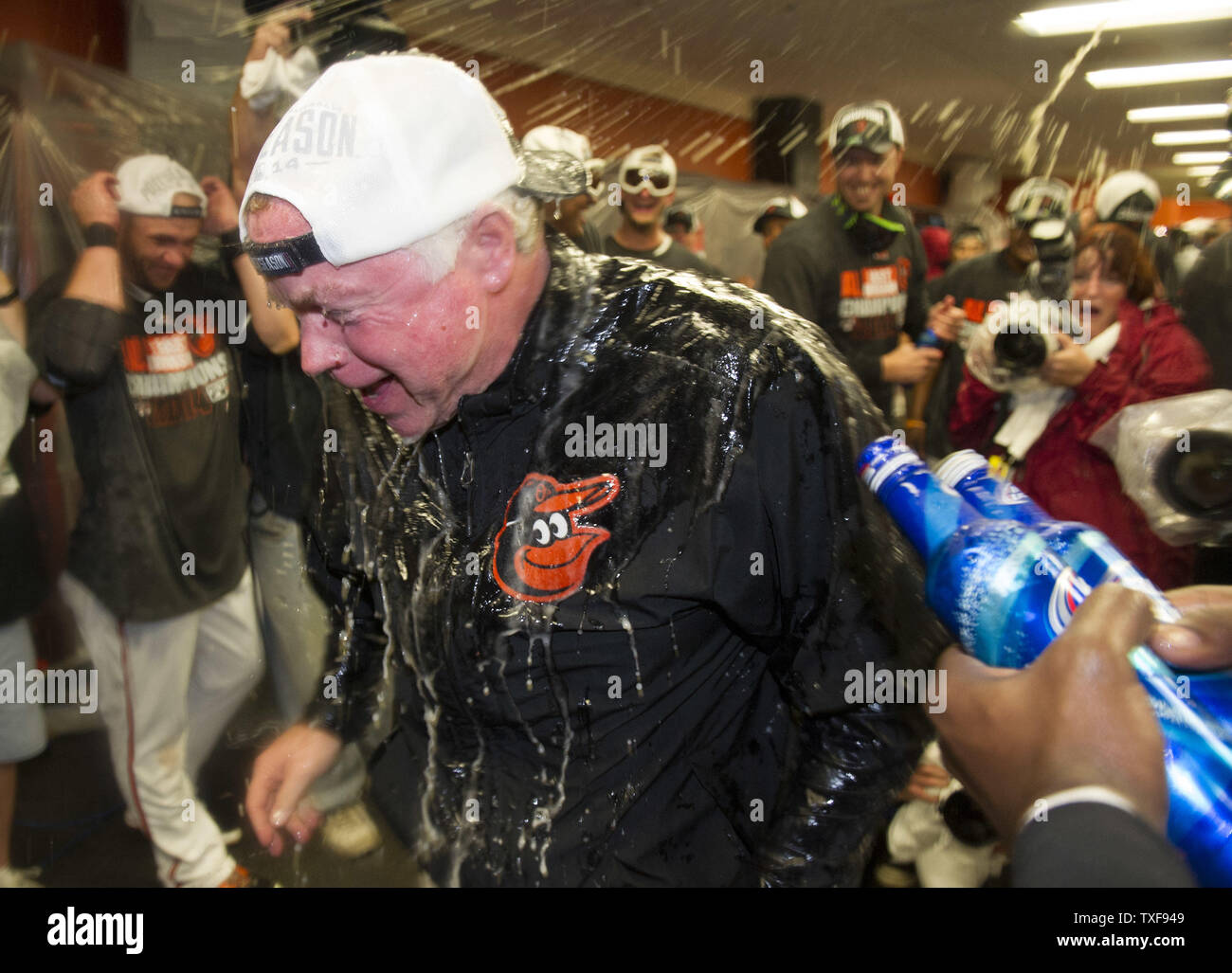 Baltimore Orioles Manager Buck Showalter è irrorato con champagne e birra come gli Orioles celebrare dopo aver vinto il campionato americano Oriente campionato, a Orioles Park a Camden Yards a Baltimora, Maryland il 16 settembre 2014. Gli Orioles sconfitto il Toronto Blue Jays 8-2. Questo è il loro primo campionato dal 1997. UPI/Kevin Dietsch Foto Stock
