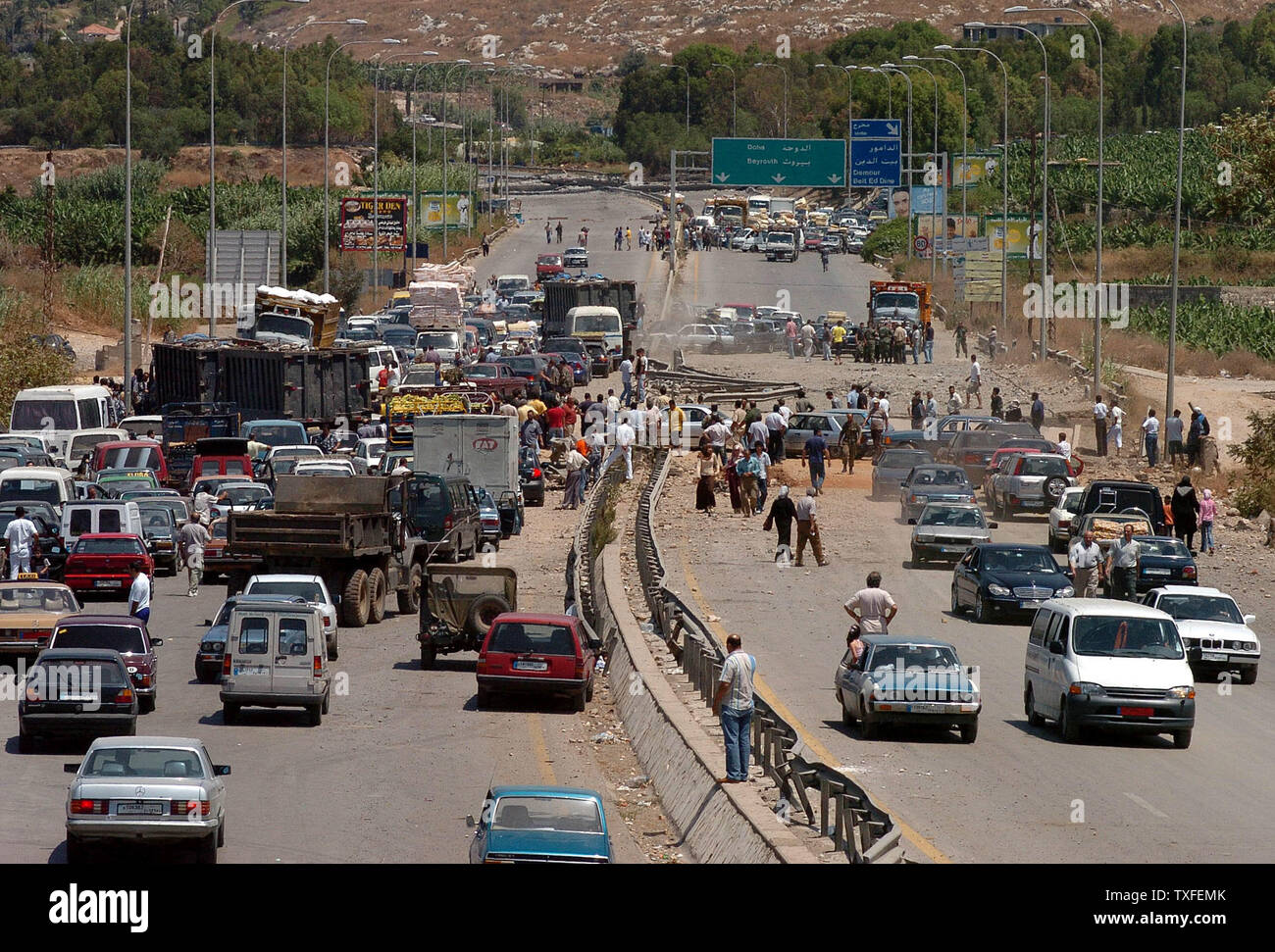 I civili libanesi tentativo di rendere la loro via di casa come essi vengono fermati da un ha bombardato il ponte vicino alla città Dammour nel sud di Beirut, ore dopo un'U.N. mediate il cessate il fuoco è entrato in effetti su Lunedì 14 Agosto, 2006. Dopo il cessate il fuoco entrato in vigore alle 08:00 (05:00 GMT) Ora locale di decine di migliaia di profughi libanesi confezionato le loro cose e diretti verso le loro case nel sud del Libano. UPI (foto) Foto Stock