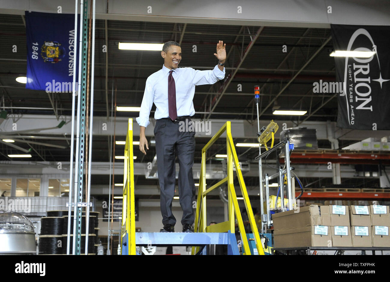 U. S. presidente Barack Obama onde ai dipendenti e agli ospiti come egli cammina sul palco per consegnare commento presso Orion Energy Systems, Inc. di Manitowoc, Wisconsin il 26 gennaio 2011. Il presidente Obama, Vice presidente Joe Biden e altri membri del gabinetto della Presidente ha viaggiato attraverso il paese mercoledì per evidenziare la somministrazione nei suoi sforzi di ricostruire l'economia americana. UPI/Brian Kersey Foto Stock