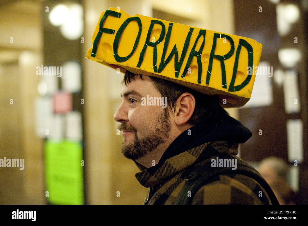 Kevin Kopplin indossa un cheesehead adornata con dello stato del Wisconsin motto presso il Campidoglio di Madison, Wisconsin il 24 febbraio 2011. Le proteste contro la legislazione di bilancio ha continuato per la XI Giornata come bill dimezzano i benefici e la revoca di contrattazione collettiva dei diritti dal membro ai lavoratori si avvicina il passaggio. UPI/Brian Kersey Foto Stock