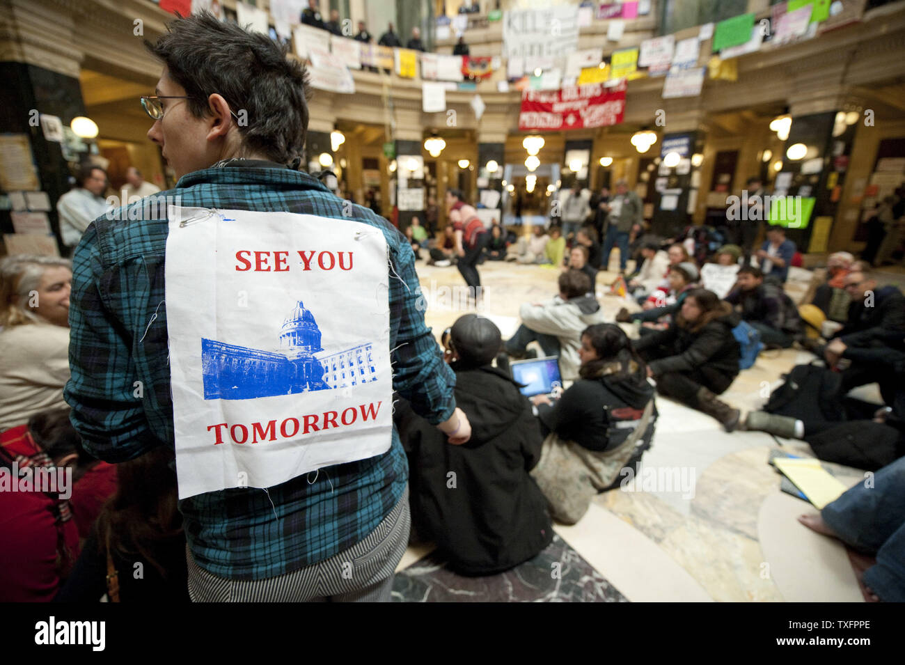 Manifestanti sedersi nella rotonda del Campidoglio il 1 marzo 2011 a Madison, Wisconsin. Un giudice ha ordinato il martedì che il Campidoglio dovrebbe essere aperto al pubblico " durante le ore lavorative e a volte quando questioni governative, come le audizioni, sessioni di ascolto e la corte gli argomenti sono condotte." Sebbene i manifestanti, occupando il Campidoglio per quindici giorni, non sono stati costretti a lasciare il pubblico è stato impedito di entrare l'edificio poiché esso chiuso a 4 p.m. domenica. UPI/Brian Kersey Foto Stock