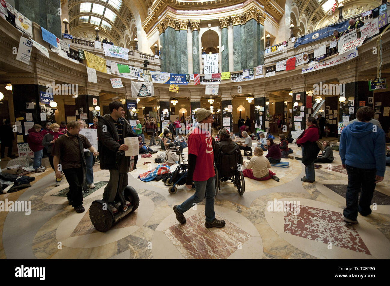 Manifestanti marzo intorno alla rotonda del Campidoglio il 1 marzo 2011 a Madison, Wisconsin. Un giudice ha ordinato il martedì che il Campidoglio dovrebbe essere aperto al pubblico " durante le ore lavorative e a volte quando questioni governative, come le audizioni, sessioni di ascolto e la corte gli argomenti sono condotte." Sebbene i manifestanti, occupando il Campidoglio per quindici giorni, non sono stati costretti a lasciare il pubblico è stato impedito di entrare l'edificio poiché esso chiuso a 4 p.m. domenica. UPI/Brian Kersey Foto Stock