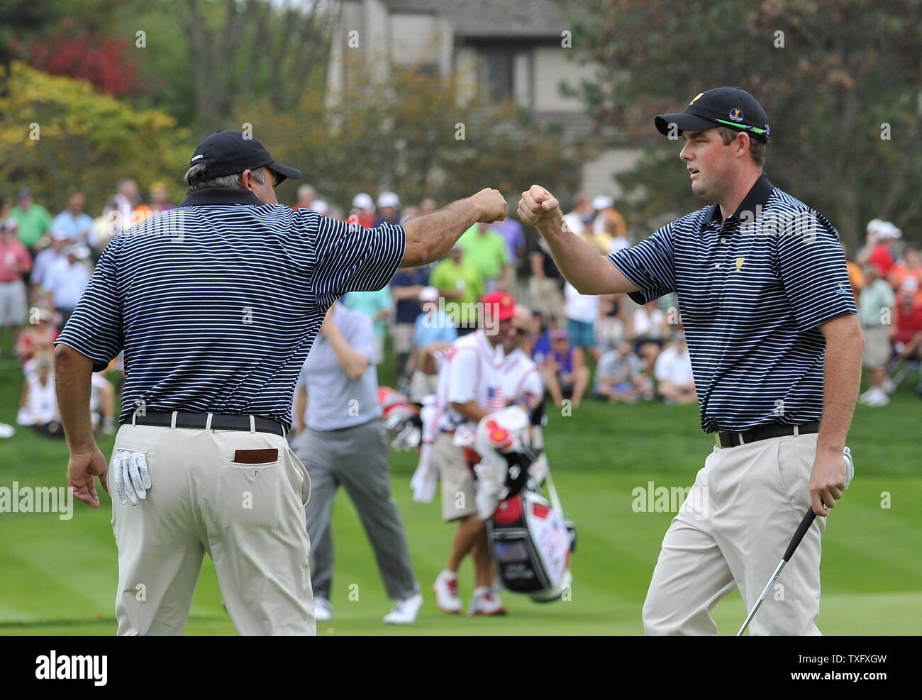 Il team internazionale di stati Angel Cabrera dell Argentina (L) si congratula con il compagno di squadra Marc Leishman di Australia dopo Leishman affondato un birdie putt sul quinto foro durante il secondo turno 4 concorrenza contro gli Stati Uniti Team al 2013 Presidenti Cup a Muirfield Village Golf Club in Dublin, Ohio il 4 ottobre 2013. UPI/Brian Kersey Foto Stock