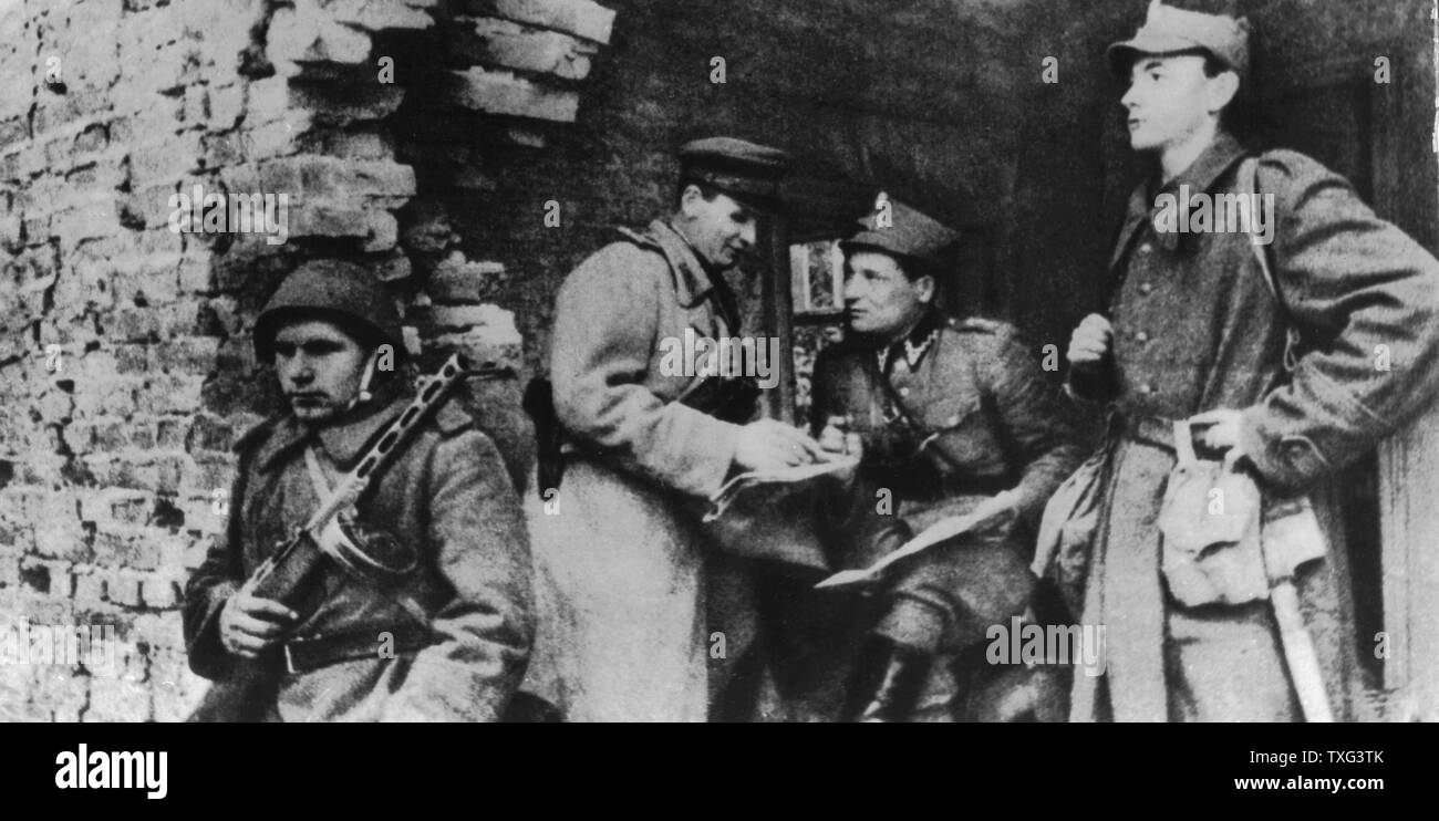 I soldati del primo polacco esercito nelle rovine di Varsavia, al momento dell'insurrezione del ghetto (agosto-settembre 1944). Il primo polacco esercito era parte del maresciallo Jukov del primo fronte bielorusso (gruppo di eserciti). Essa ha partecipato alla liberazione di Varsavia e Polonia e la battaglia di Berlino. Questi uomini nel quartiere Praga stanno parlando con un funzionario sovietico. Foto Stock