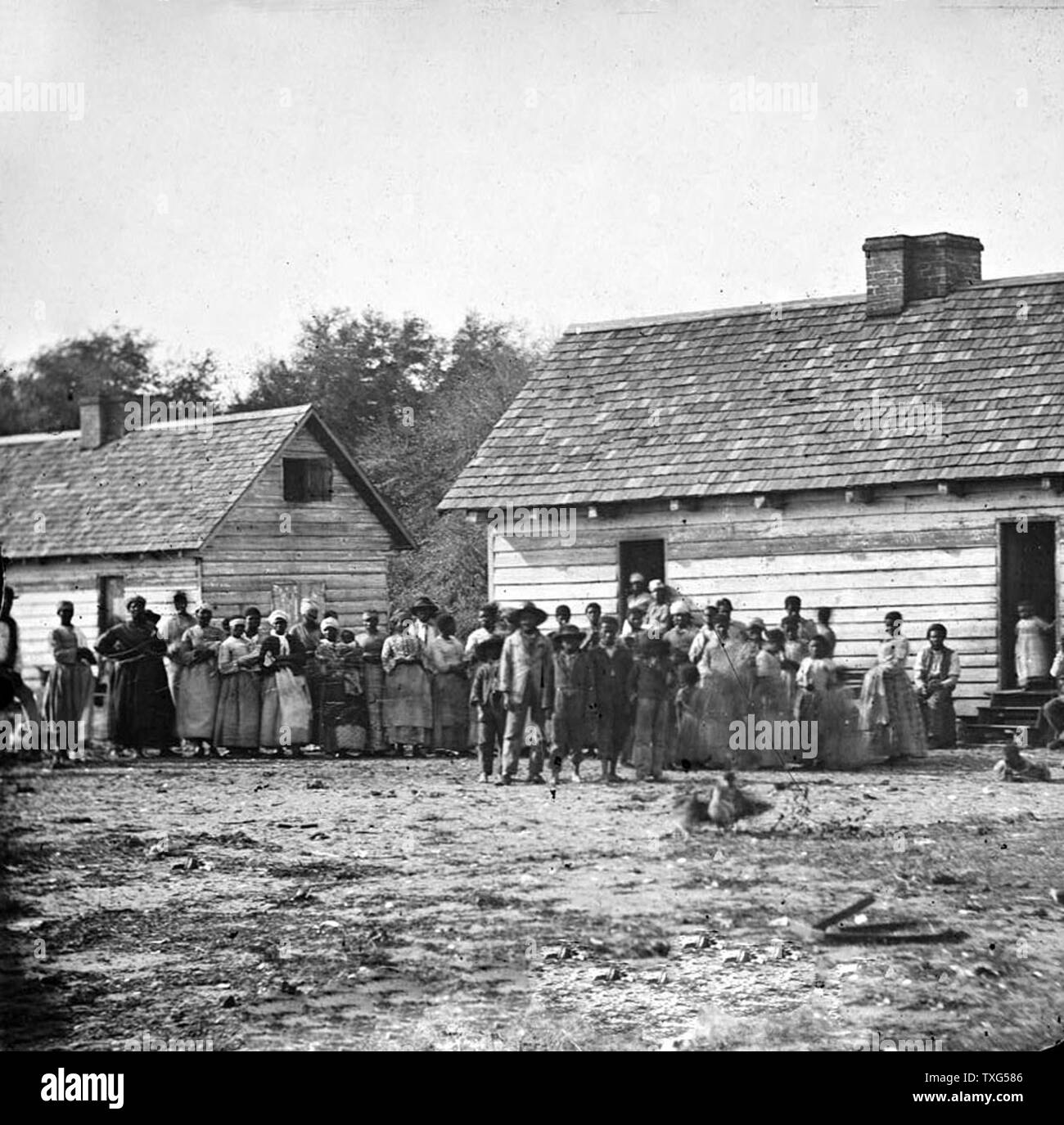 Plantation schiavi riuniti outdside loro capanne - Virginia Foto Stock