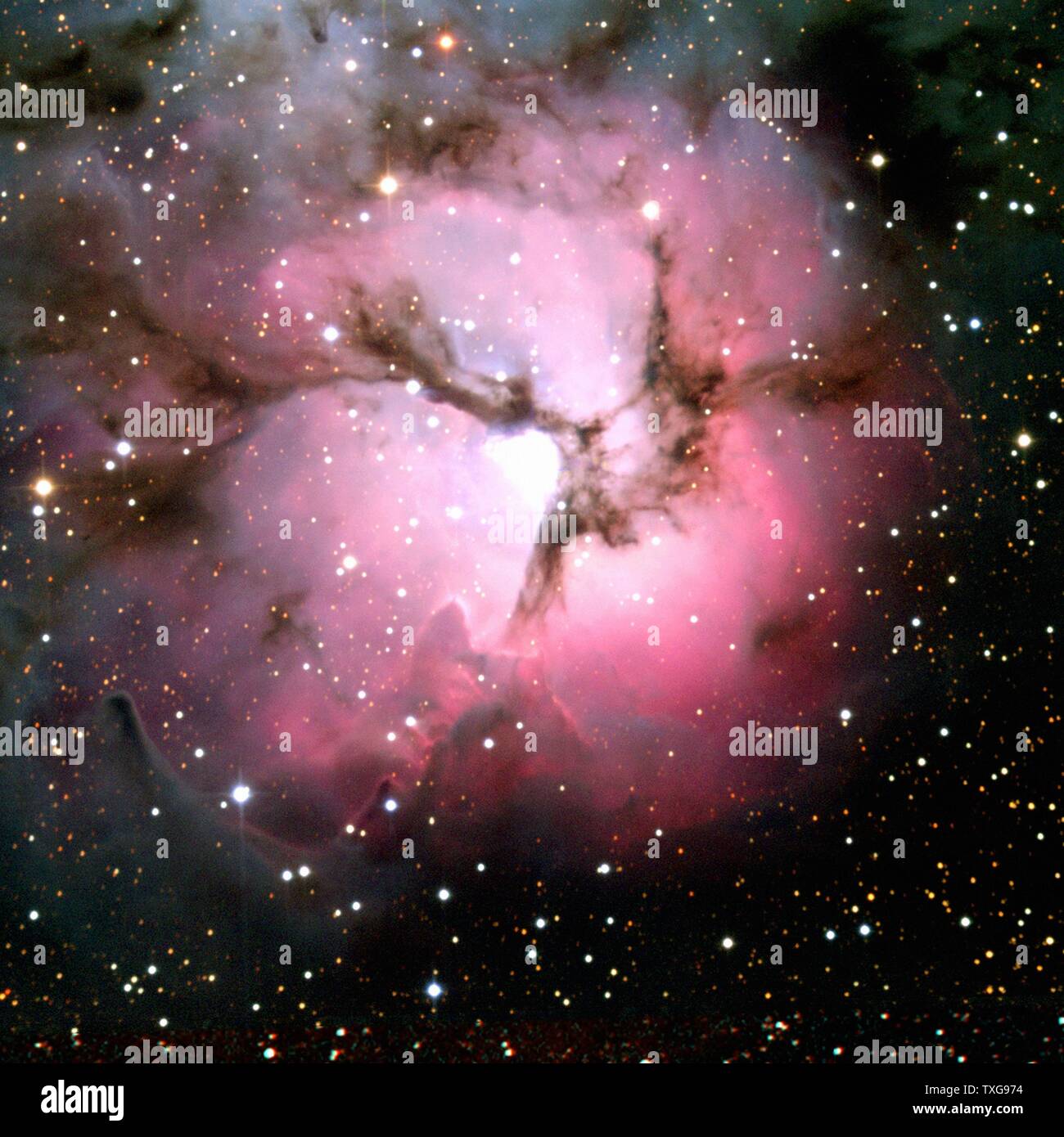 Telescopio spaziale Spitzer composite di luce visibile e raggi infrarossi vedute dell'incandescente Trifid Nebula, una gigantesca star-la formazione di nubi di gas e polvere si trova nella costellazione del Sagittario. Credit NASA Foto Stock