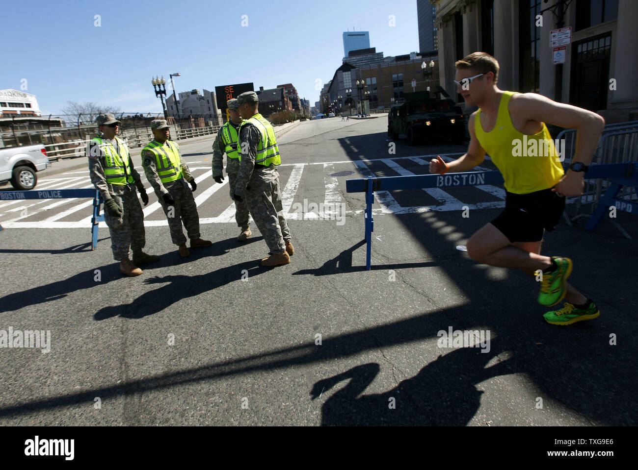 Un runner fa avanzare passato un esercito nazionale Guard checkpoint su Boylston Street a Boston, Massachusetts, il 16 aprile 2013. La strada e le strade circostanti sono bloccati come autorità federali e statali indagare due bombe che detonato vicino al traguardo della Maratona di Boston lunedì pomeriggio uccidendo 3 e il ferimento di altre 150. UPI/Matthew Healey Foto Stock