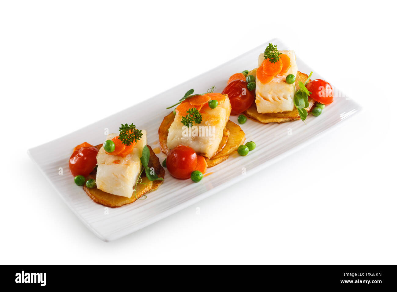 Di pesce preparati con verdure sulla piastra bianca. Isolato su sfondo bianco. Foto Stock