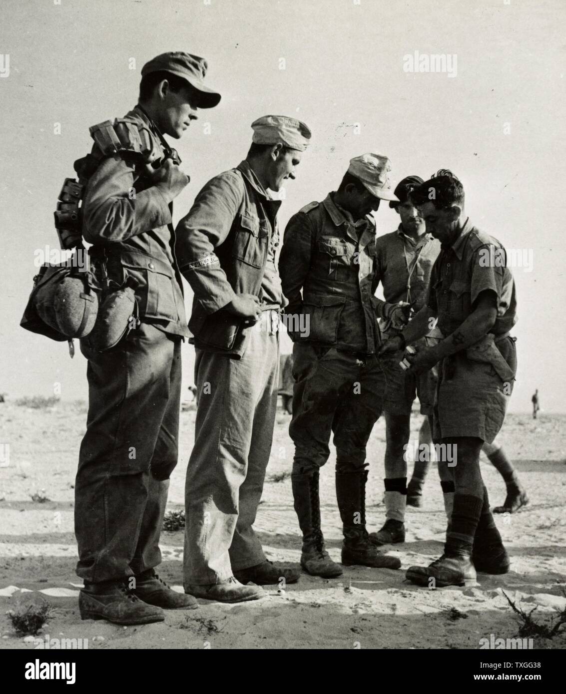 Prigionieri tedeschi che è cercato dopo essere stato catturato a sud di El Alamein, essi erano membri del tedesco della divisione crack, novantesimo luce Div. e indossavano la fascia dell'Afrikakorps Foto Stock