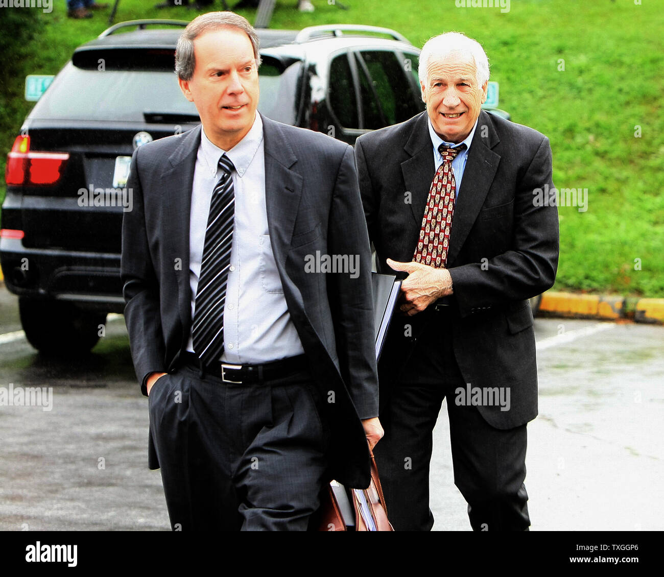 Penn State ex assistente allenatore di calcio Jerry Sandusky (R) e il suo avvocato Joe Amendola arrivano al centro County Courthouse il primo giorno della giuria di selezione per questo trial in Bellefonte, Pennsylvania il 5 giugno 2012. Sandusky è caricato con 52 conta di molestare 10 ragazzi nel corso di un periodo di quindici anni. UPI/George M poteri Foto Stock