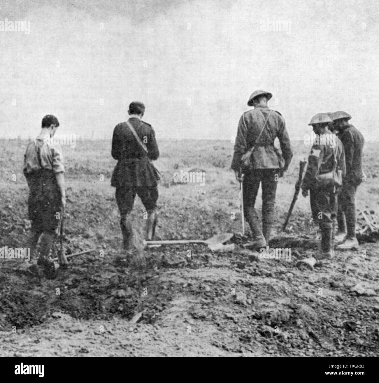 La prima guerra mondiale: Esercito cappellano di conduzione del servizio di sepoltura nel campo mentre il partito di sepoltura stand, prestando loro rispetta c.1916 Foto Stock