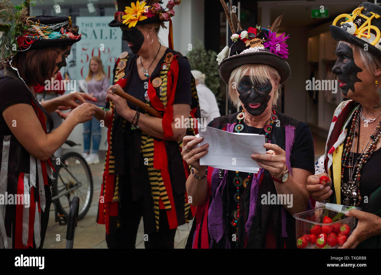 Morris ballerini tradizionali e abiti colorati e cappelli con piume discutere una performance prima di prestazioni in Beverley, Yorkshire, Regno Unito. Foto Stock