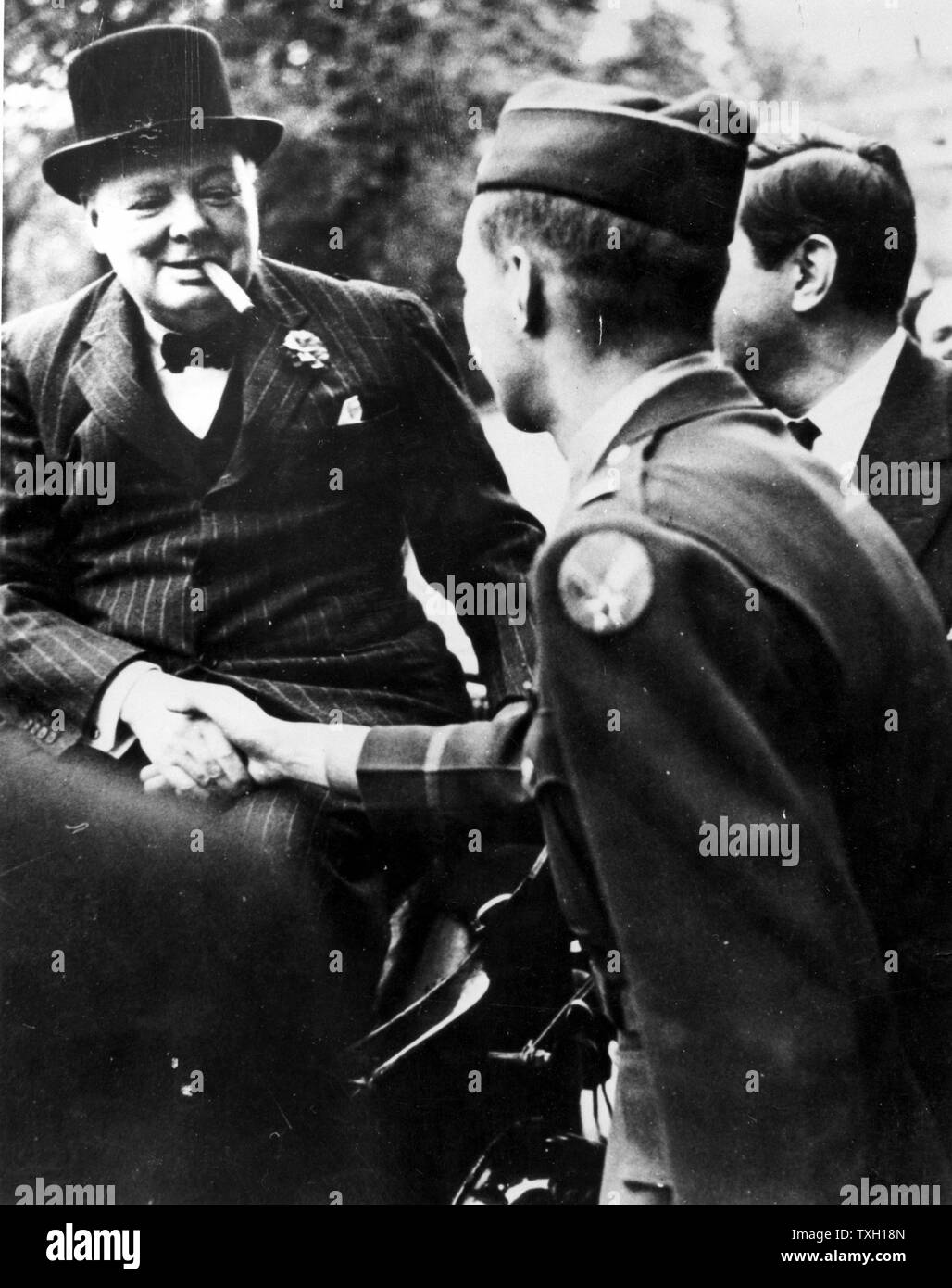 Winston Leonard Spencer Churchill (1874-1965) statista britannico. Churchill, sorridente e fumare un sigaro, stringono le mani con un soldato. La Seconda Guerra Mondiale Foto Stock