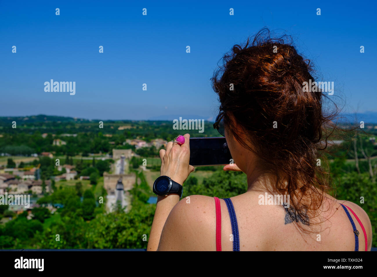 Ragazza brunetta scattando foto con il telefono a Valleggio sul Mincio, Italia Foto Stock