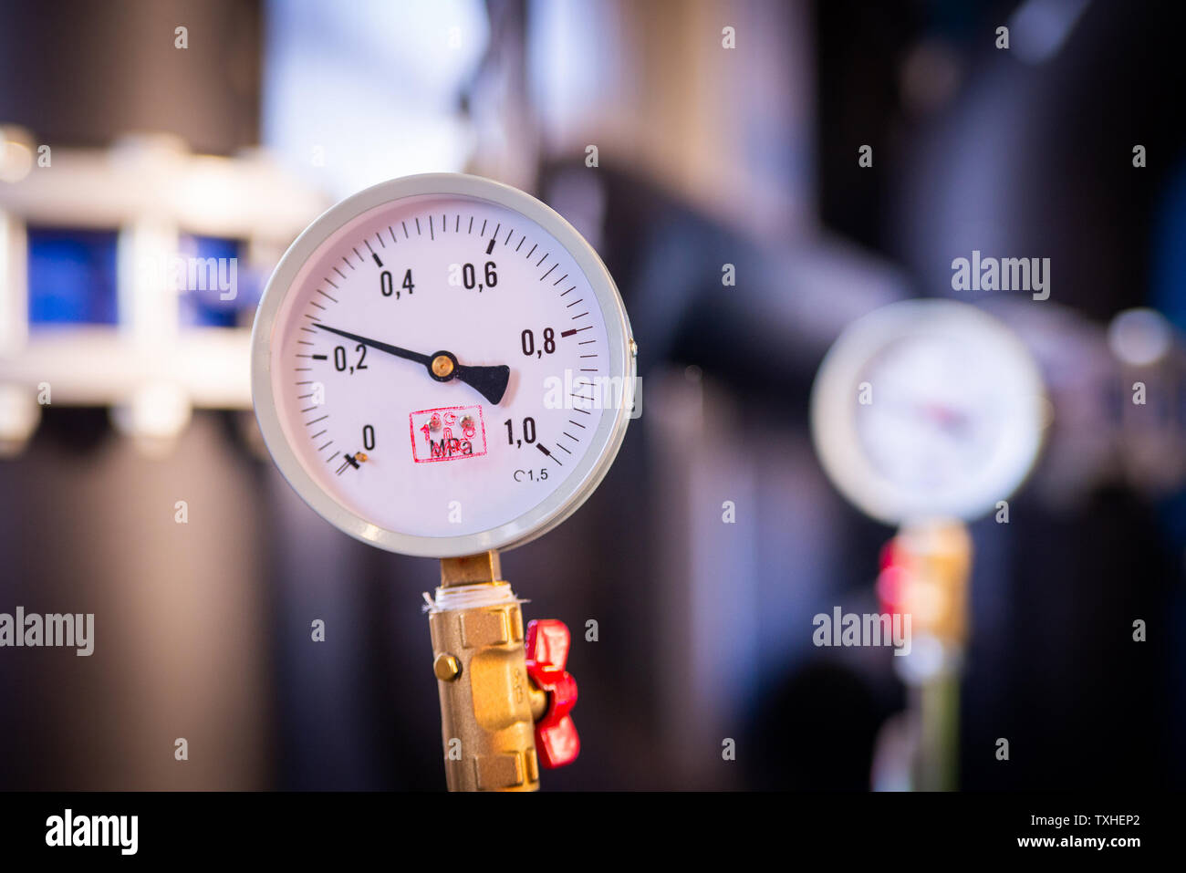 Vista dettagliata del manometro di misura della pressione del gas. Le tubazioni e le valvole ad impianto industriale. Manometro, strumento di misurazione vicino sul acqua calda, olio o Foto Stock