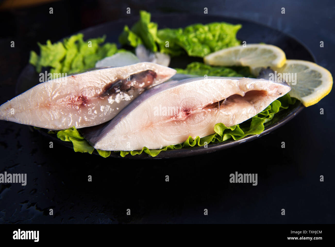 Affettato pomfret argento con lattuga e le fette di limone. Foto Stock