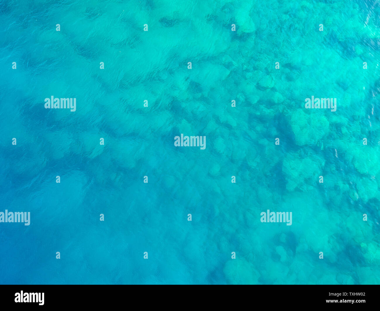 Nel profondo. Vista da sopra di una chiara aqua blue sea con formazioni di roccia sottostante. Grande immagine di sfondo Foto Stock