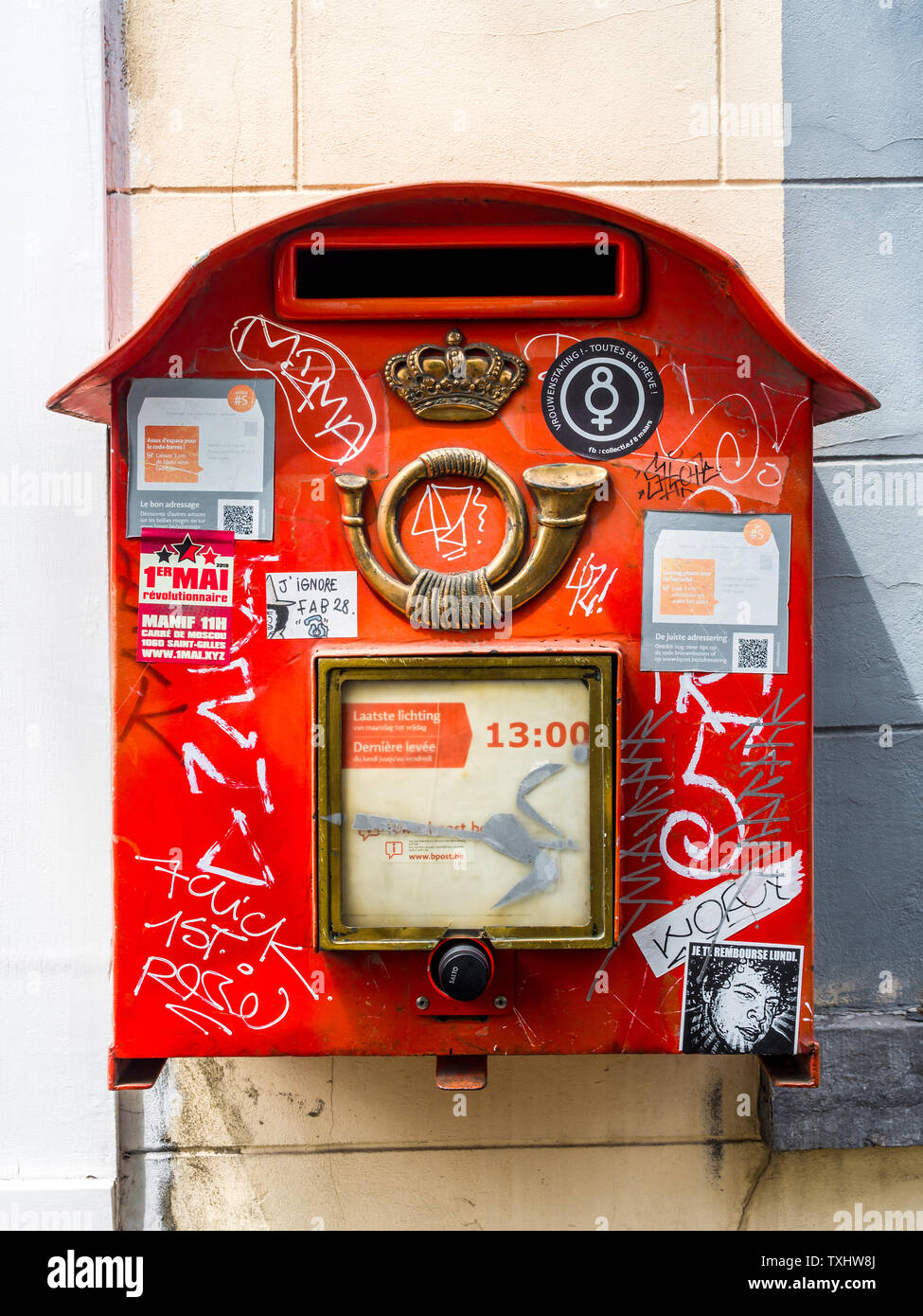 Rosso "Posta belga' post box coperti con adesivi e graffiti, Bruxelles, Belgio. Foto Stock