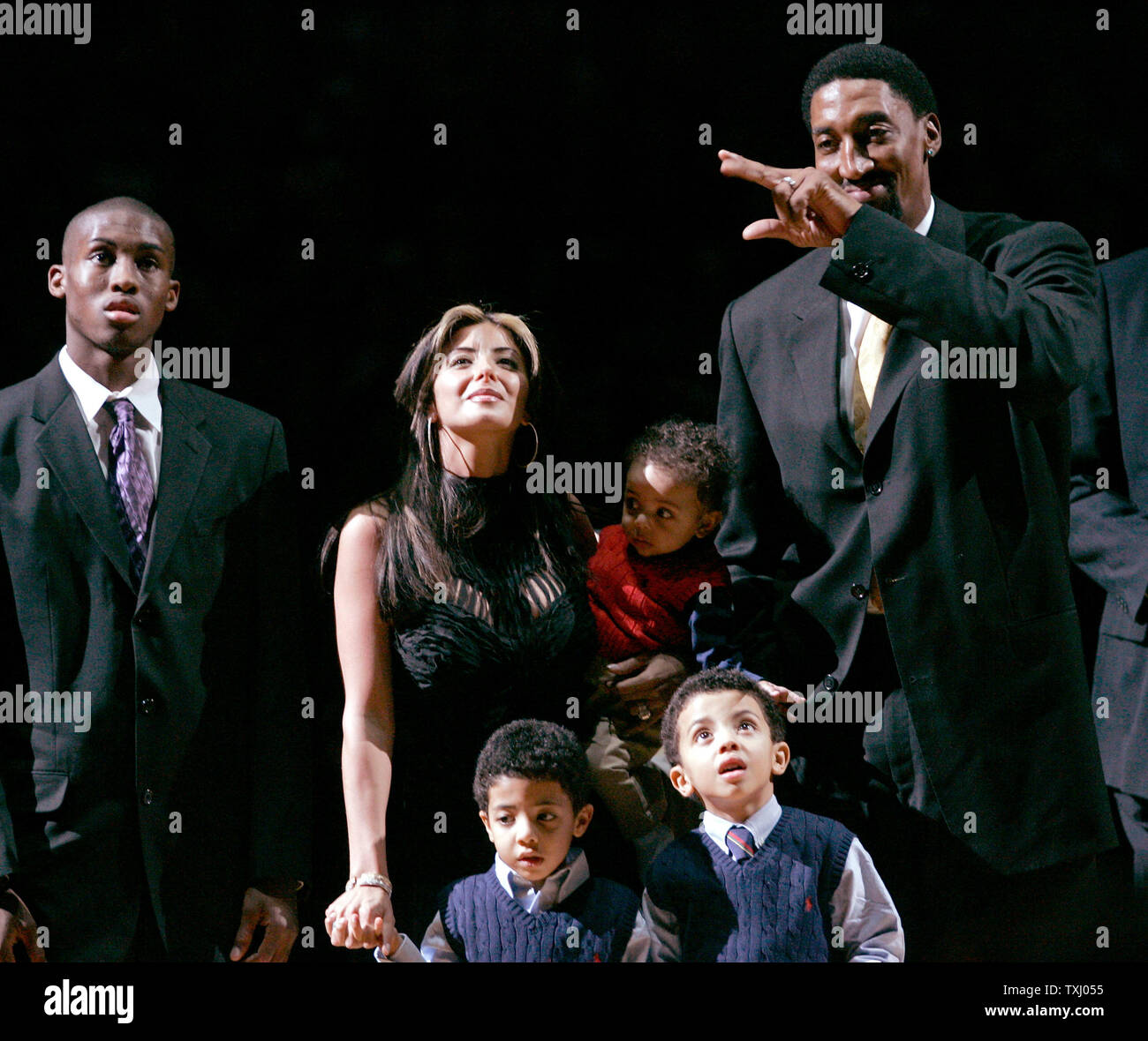 Ex Chicago Bulls player Scottie Pippen, destra, sua moglie Larsa e i suoi figli guardare come un banner con Pippen il numero è appeso al soffitto della United Center su dicembre 9, 2005 a Chicago. Pippen il numero era stato ritirato in un tempo di emisaturazione cerimonia durante la partita contro i Los Angeles Lakers. (UPI foto/Brian Kersey) Foto Stock