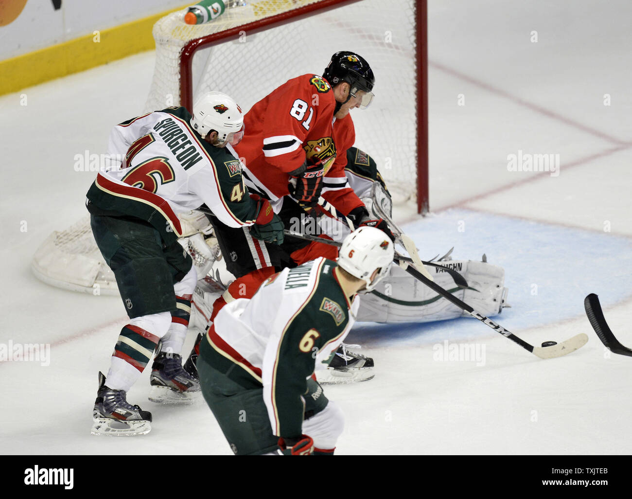 Chicago Blackhawks' Marian Hossa (81) punteggi passato Minnesota Wild's Jared Spurgeon (L) e goalie Josh Harding durante il secondo periodo di gioco 5 del NHL Western Conference Quarti di finale durante il 2013 la Stanley Cup Playoffs presso la United Center a Chicago il 9 maggio 2013. UPI/Brian Kersey Foto Stock