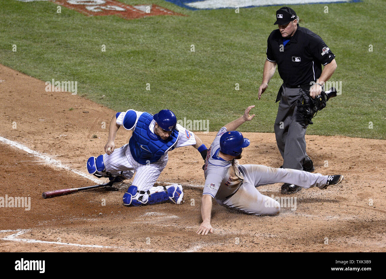 New York Mets' Daniel Murphy (C) punteggi passato Chicago Cubs catcher Miguel Montero (L) su una terra colpita da Lucas Duda durante il settimo inning di gioco 3 di Campionato Nazionale serie a Wrigley Field a Chicago il 20 ottobre 2015. Il Mets sconfitti i Cubs 5-2 e portare il meglio di sette serie 3-0. Foto di Jim Prisching/UPI Foto Stock