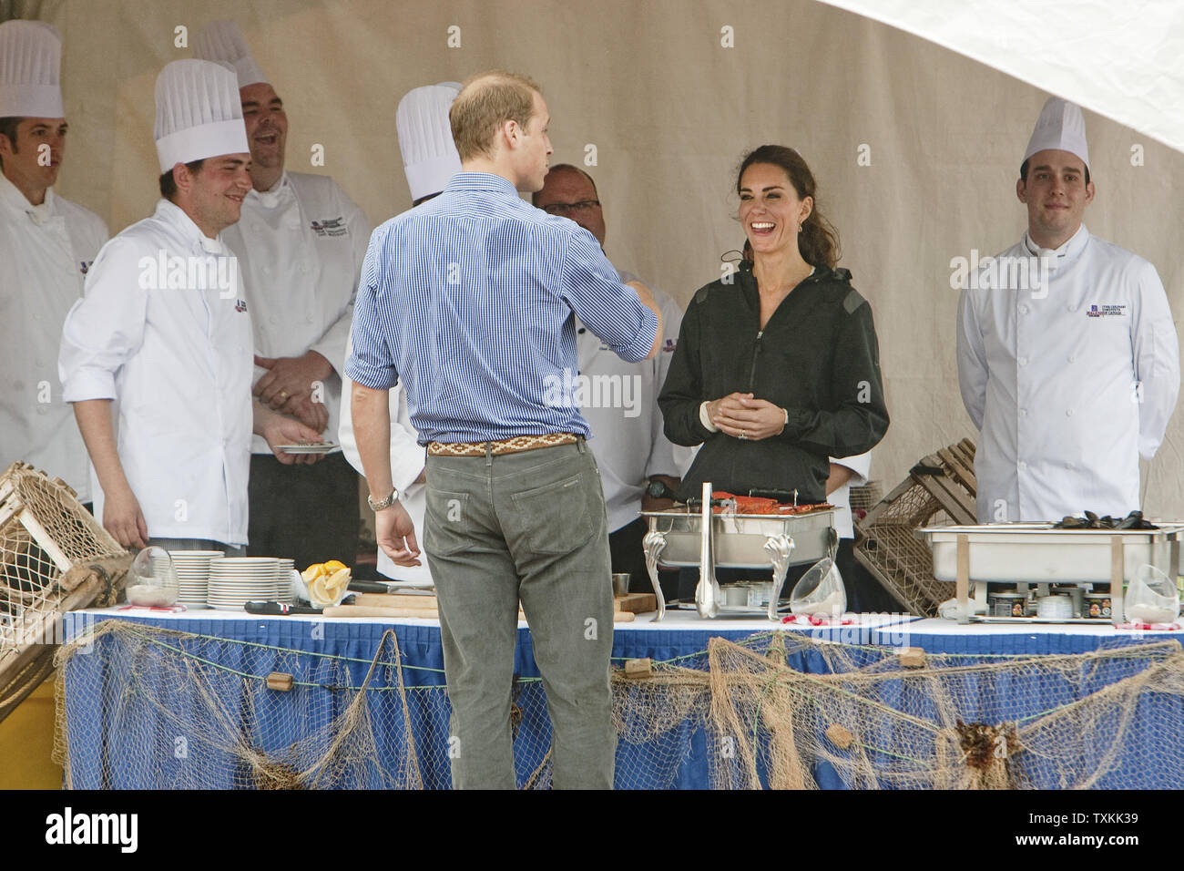 Il principe William e sua moglie Kate, il Duca e la Duchessa di Cambridge, parlare con gli chef preparano piatti di pesce sulla spiaggia al Dalvay By-The-mare durante il loro tour reale vicino a Charlottetown, Prince Edward Island, 4 luglio 2011. UPI/Heinz Ruckemann Foto Stock