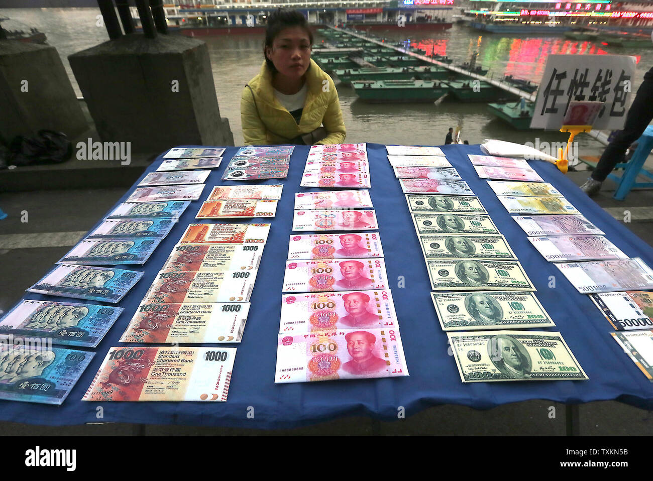 Copie di Souvenir di diverse banconote internazionali (L-R) dalla Cina yuan, Hong Kong dollar, Cina yuan, il dollaro statunitense e l'E.U.'s euro sono venduti a un hotspot del turismo a Chongqing il 4 novembre 2016. Della Cina di capitale è stato invischiato in una ondata di frenesia dollar-selling il mese scorso come la fuga di capitali e un deprezzamento yuan vide riserve valutarie capovolto da 80 miliardi di dollari, ripresa 2015's forte calo nel paese la guerra monetaria petto dopo un periodo di relativa stabilità nel 2016. Foto di Stefano rasoio/UPI Foto Stock