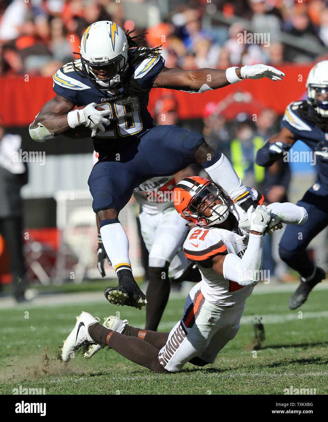 Los Angeles Chargers Melvin Gordon III tenta di saltare su Cleveland Browns defender Denzel Wardl al primo stadio di energia in Cleveland Ohio Ottobre 14, 2018. Foto di Aaron Josefczyk/UPI Foto Stock