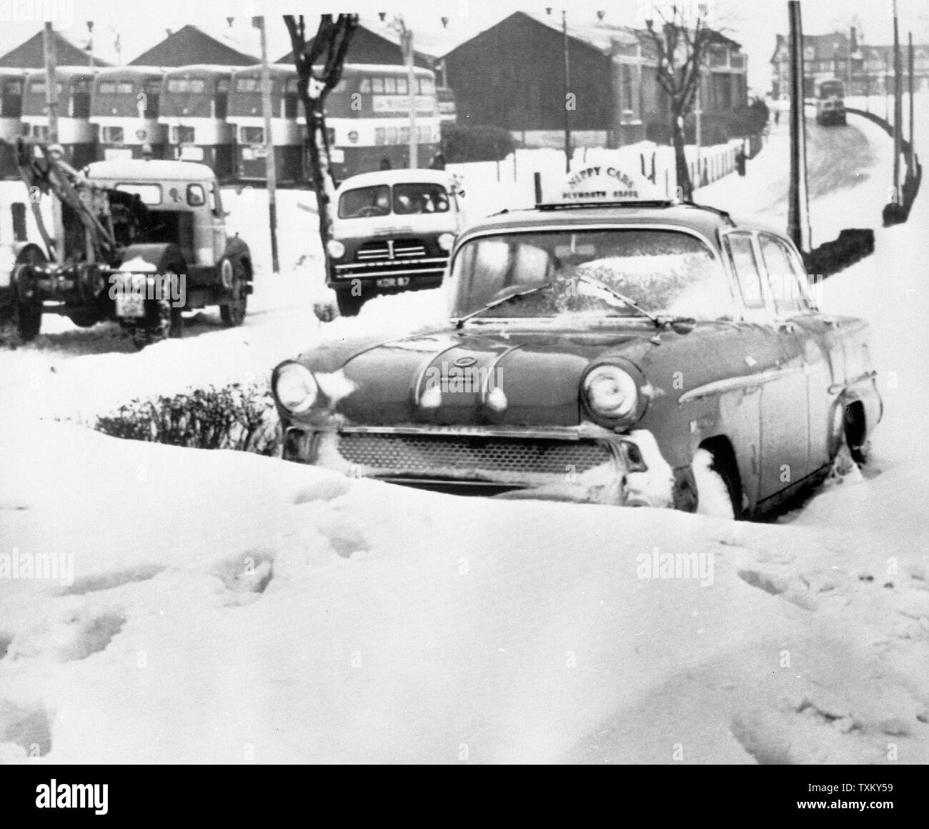 Un snowbound taxi era bloccato per tutta la notte in Alma Road, Plymouth, durante questo anno di blizzard condizioni. In fondo è la Corporation deposito autobus. Foto Stock