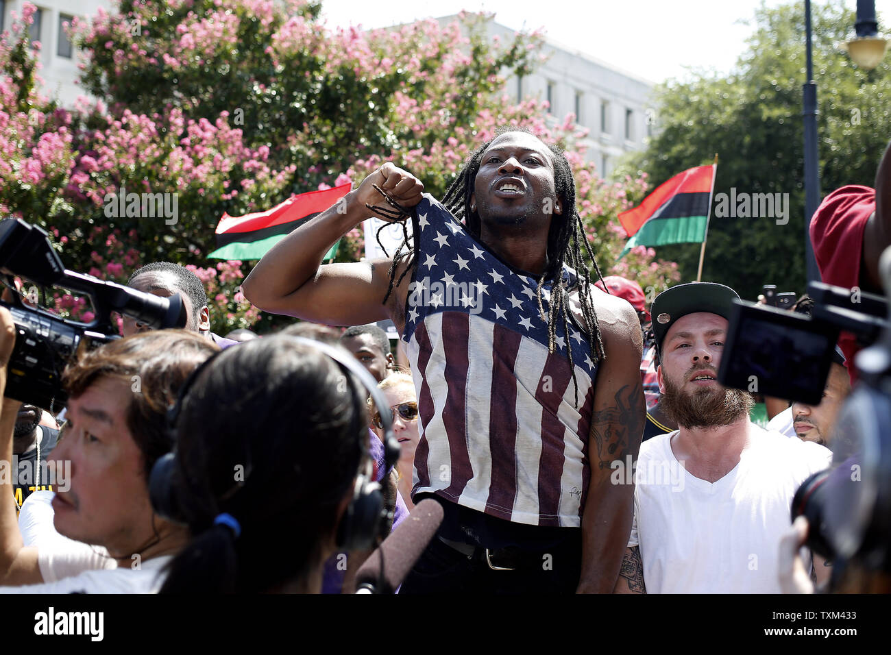 Un contatore non identificato-protestor grida a un membro del Ku Klux Klan durante un rally Luglio 18, 2015, presso il South Carolina State House a Columbia nella Carolina del Sud, che è stato tenuto per protestare contro la rimozione di un confederato battaglia bandiera dalla casa di stato motivi. Foto di Veasey Conway/UPI Foto Stock