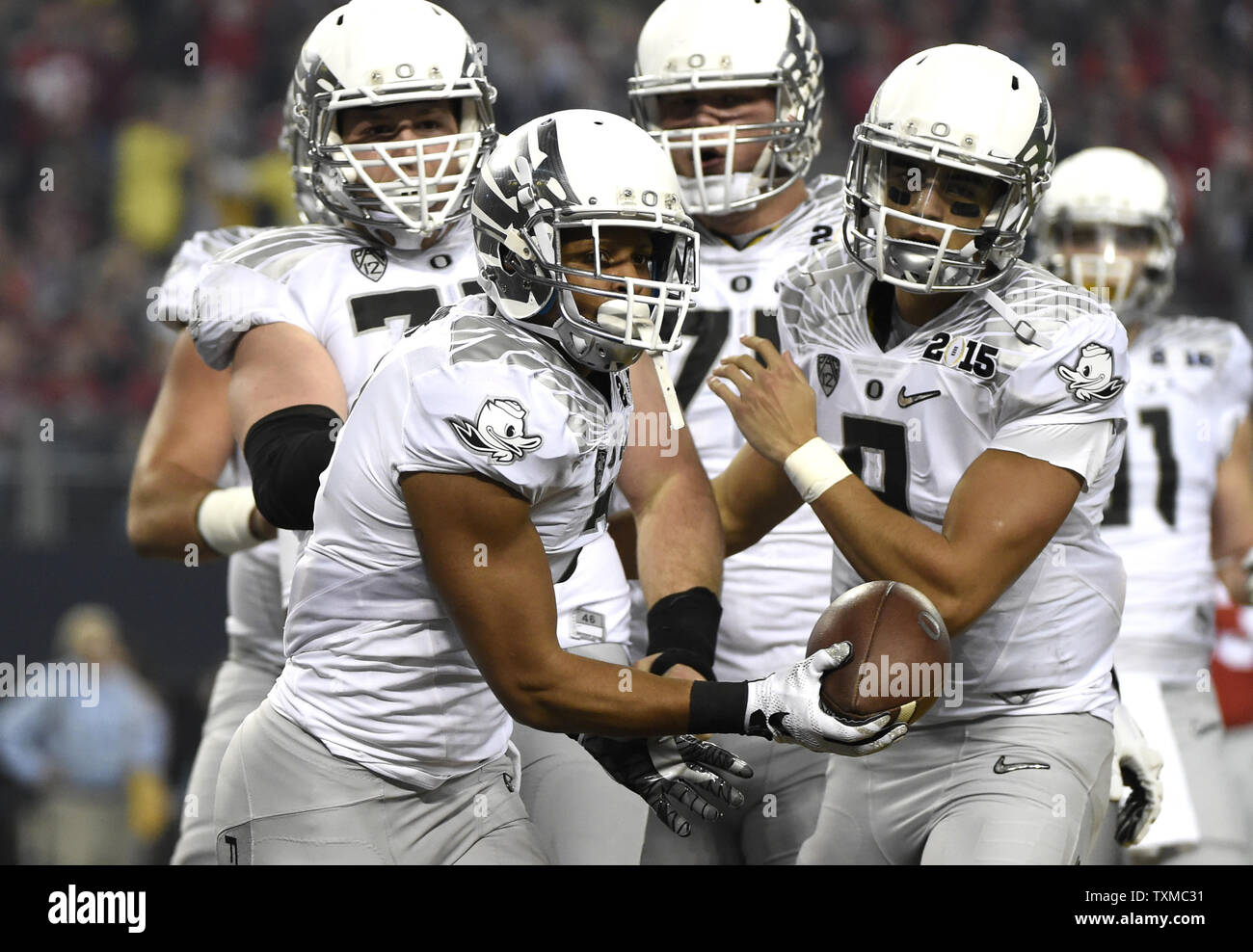 Oregon Ducks Keanon Lowe festeggia con i compagni di squadra dopo egli i punteggi su un 7 yard touchdown ricevimento nel primo trimestre contro la Ohio State Buckeyes presso il College Football Playoff Campionato Nazionale di Arlington, Texas, il 12 gennaio 2015. Foto di Kevin Dietsch/UPI Foto Stock