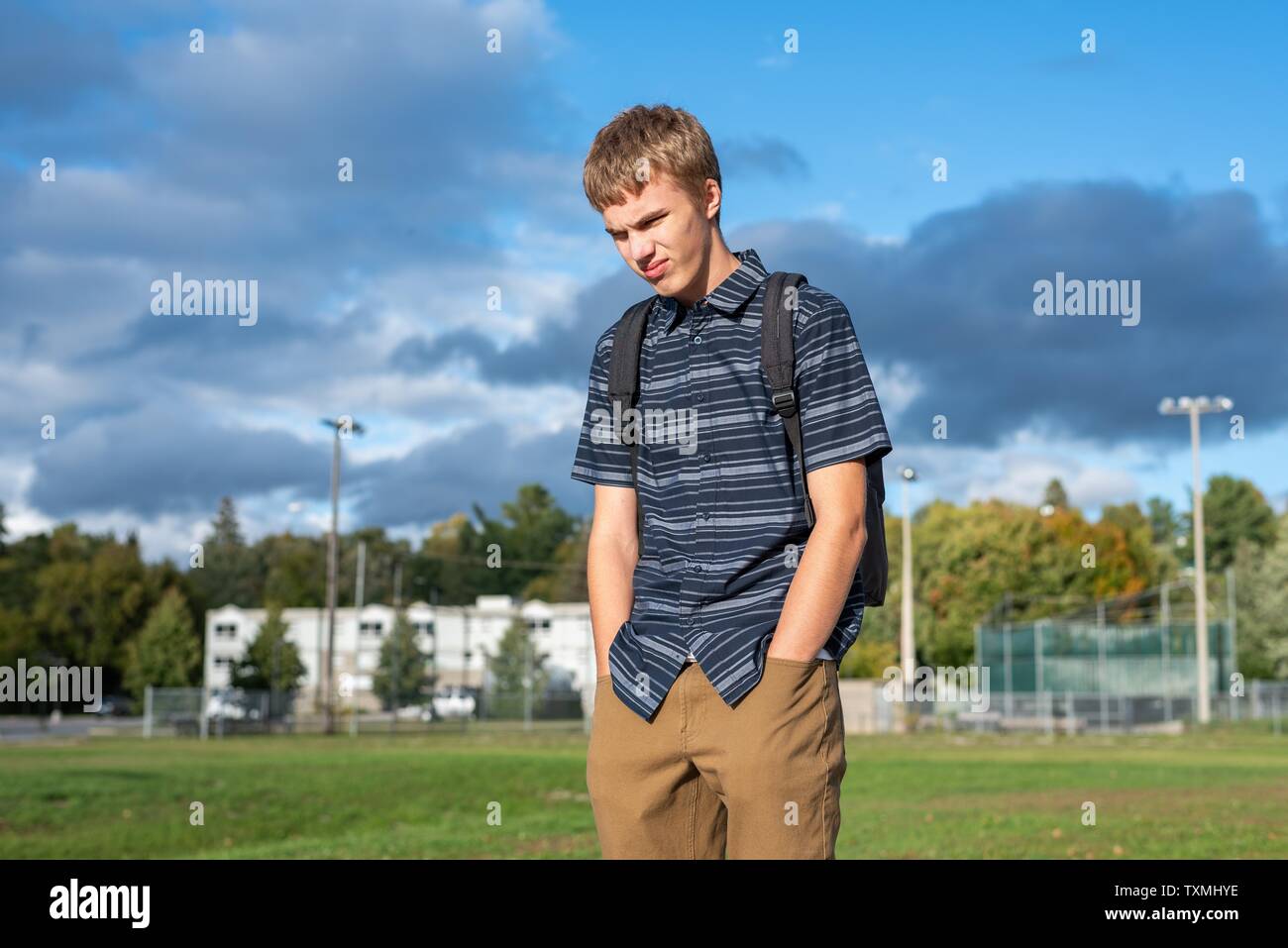 Arrabbiato studente in piedi su una passerella che conduce ad un piccolo padiglione. Foto Stock