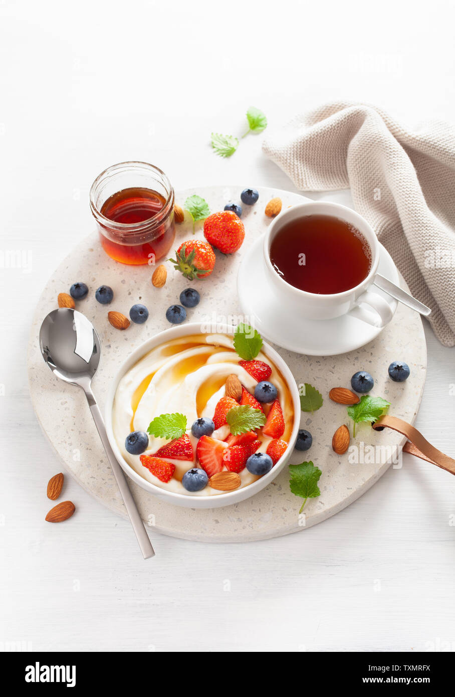 Yogurt alla fragola mirtillo mandorle miele per la colazione Foto Stock
