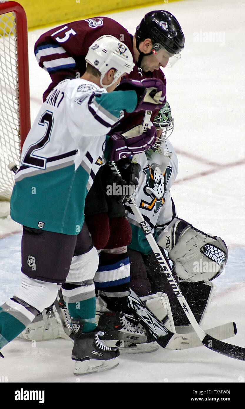 Colorado Avalanche ala sinistra Andrew Brunette (C) racchiuso a sandwich tra il Mighty Ducks di Anaheim center Todd Marchant (L) e goalie parte di Jean-Sébastien Giguere (R) segna il gol vincente nel terzo periodo presso il Pepsi Center di Denver Marzo 28, 2006. Colorado ha vinto 4-3 oltre ad Anaheim. (UPI foto/Gary C. Caskey) Foto Stock