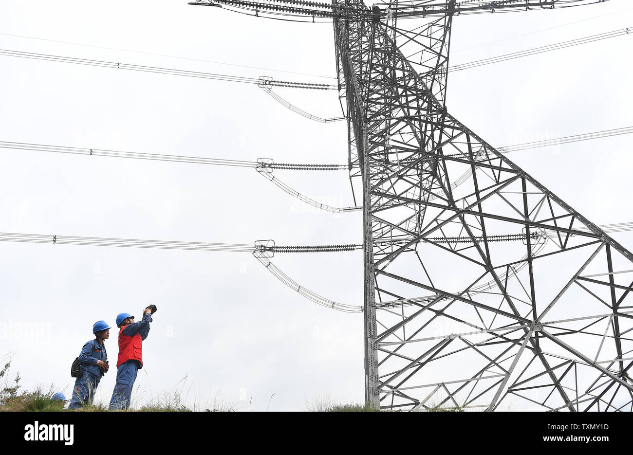 (190625) -- XINING, Giugno 25, 2019 (Xinhua) -- Xining ramo membri dello staff della griglia di Stato di Qinghai potenza elettrica società di manutenzione di lavorare a Xiaoxia Township, Haidong città del nord-ovest della Cina di Provincia di Qinghai, il 19 giugno 2019. Cina nord-occidentale della Provincia di Qinghai completato un 15-giorno tutti energia pulita di alimentazione, prova l'impostazione di un nuovo record dopo il successo di nove giorni di prova lo scorso anno, la griglia di Stato Qinghai società elettrica ha annunciato lunedì. Quasi 6 milioni di persone nella provincia, che confina con la regione autonoma del Tibet, utilizzato solo l'elettricità generata dall'eolico, solare e idraulico Foto Stock