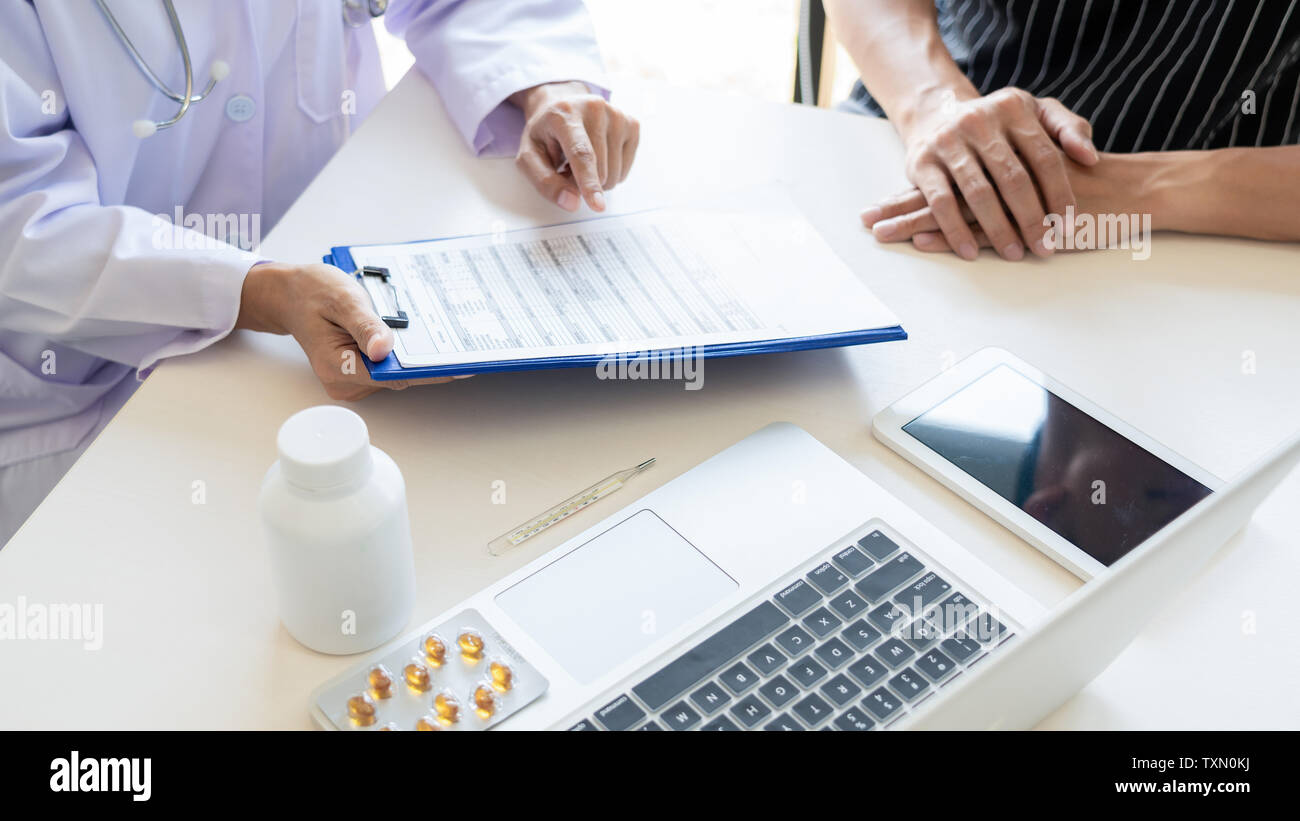 Medico spiegando per il paziente e che mostra i record medici informazioni diagnosi e sintomi del paziente in una fase di consultazione e di assicurazione medica nozione Foto Stock