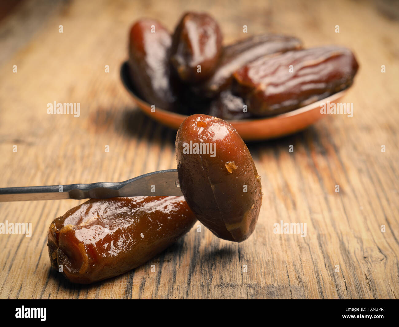 Organici dolci di datteri secchi su una tavola in legno rustico Foto Stock