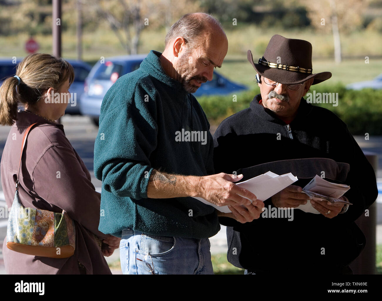 Scott Brabec (C) e Clarence Martinez guarda oltre il loro turno di scrutinio cheat fogli durante l'attesa per il voto anticipato il polling per aprire in Arvada, Colorado, un'area suburbana di Denver comunità, il 25 ottobre 2008. Gli elettori del Colorado ha iniziato a voto anticipato il 20 ottobre con voto anticipato che termina il 31 ottobre 2008. (UPI foto/Gary C. Caskey) Foto Stock